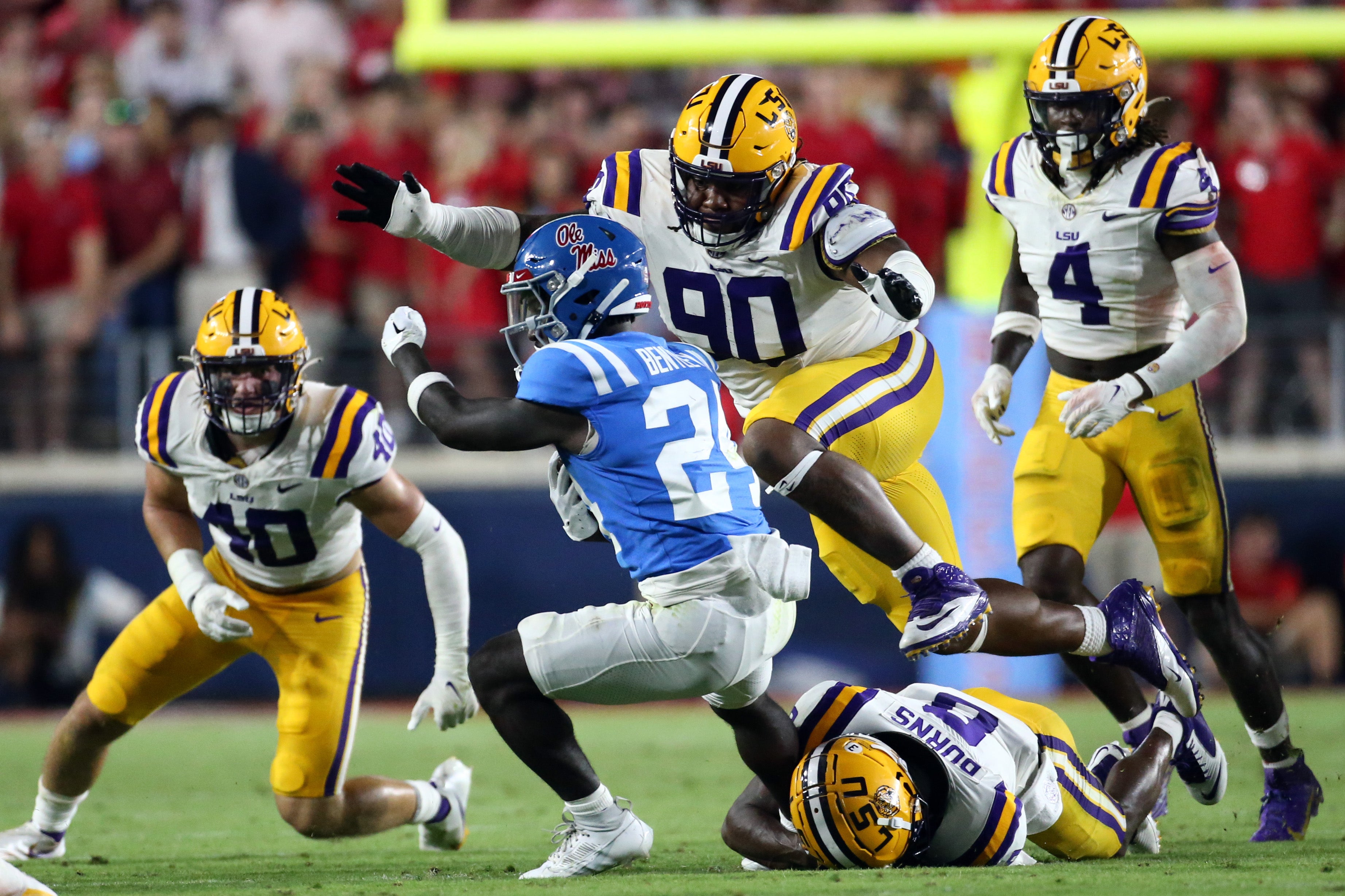 Sep 30, 2023; Oxford, Mississippi, USA; LSU Tigers defensive linemen Jacobian Guillory (90) and defensive back Major Burns (8) tackle Mississippi Rebels running back Ulysses Bentley IV (24) during the second half at Vaught-Hemingway Stadium.