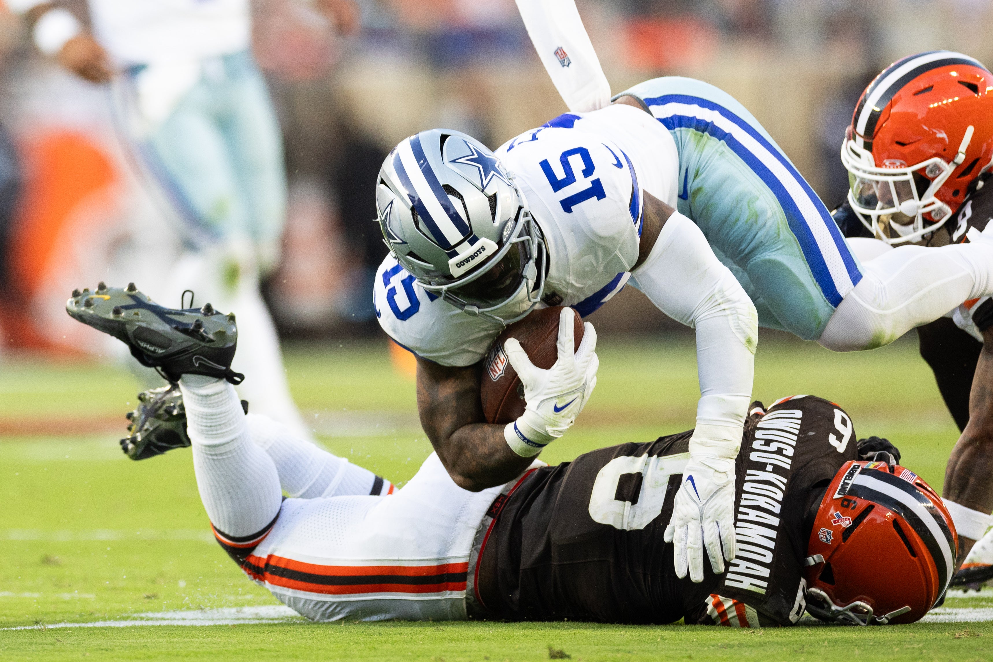Dallas Cowboys running back Ezekiel Elliott (15) gets tackled by Cleveland Browns linebacker Jeremiah Owusu-Koramoah (6) during the fourth quarter at Huntington Bank Field.