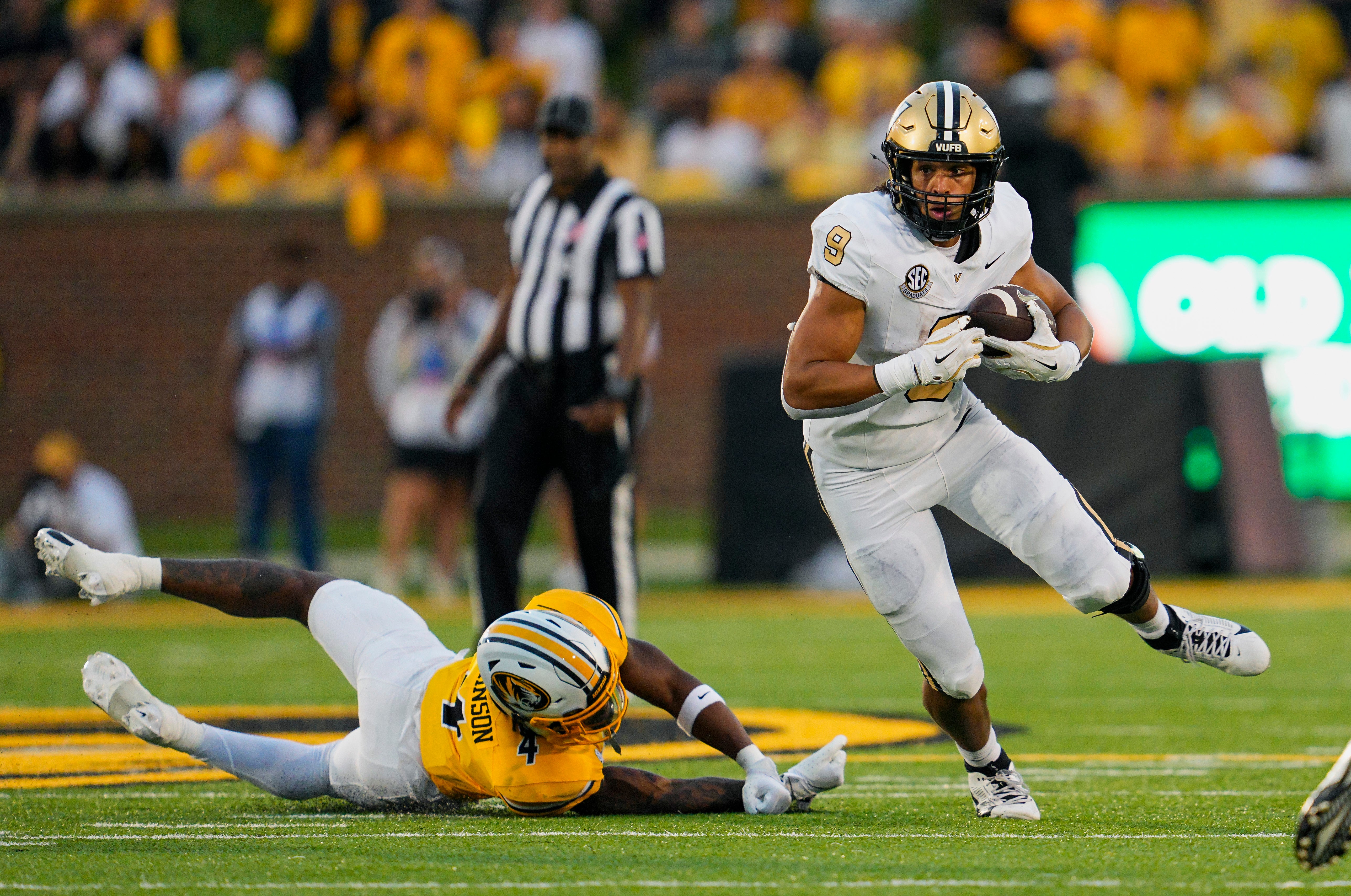 Missouri, USA; Vanderbilt Commodores tight end Eli Stowers (9) runs with the ball past Missouri Tigers safety Tre'Vez Johnson (4) during the second half at Faurot Field at Memorial Stadium.