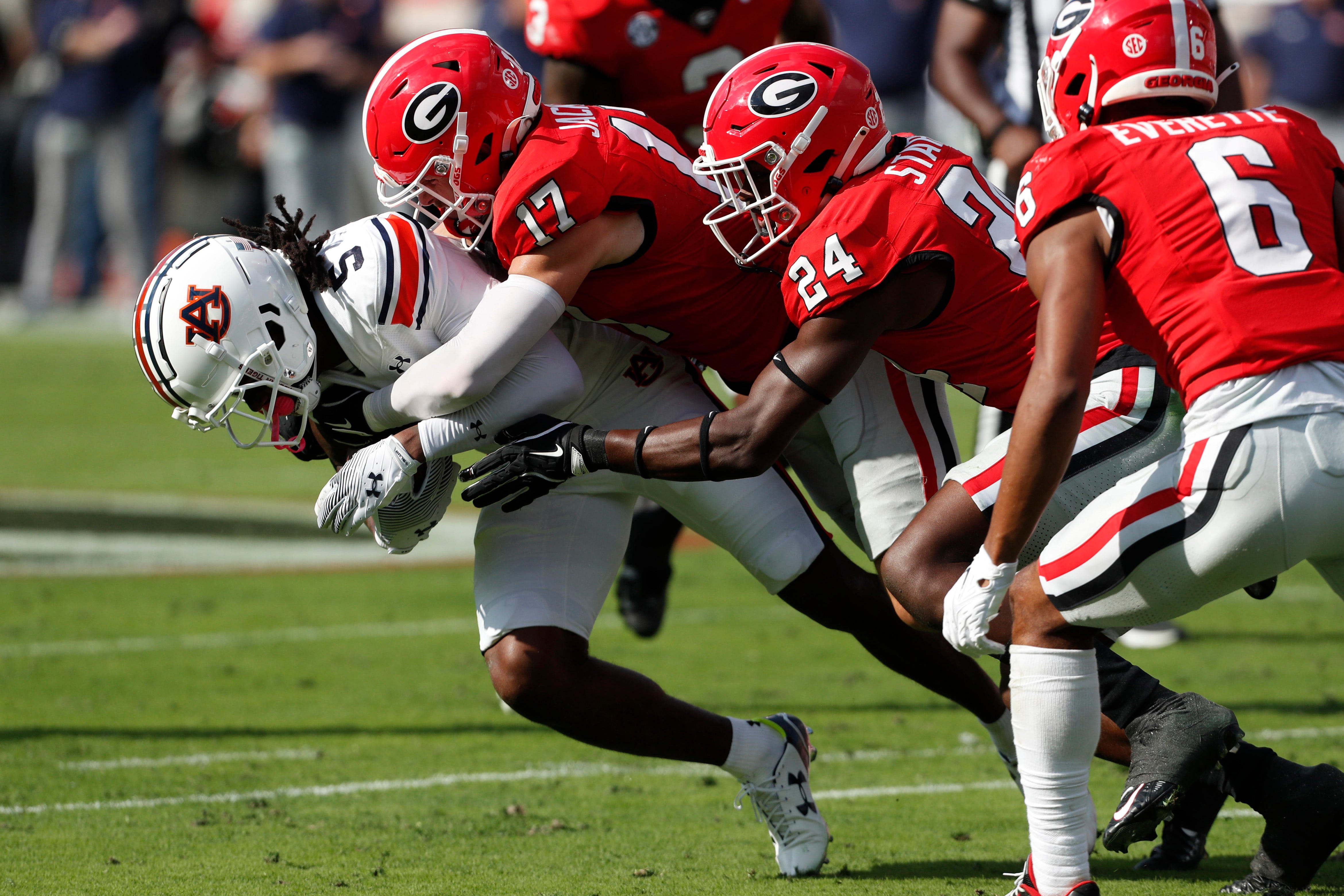 Auburn wide receiver KeAndre Lambert-Smith (5) is stopped by Georgia defensive back Dan Jackson (17) during the first half of a NCAA college football game in Athens, Ga., on Saturday, Oct. 5, 2024.