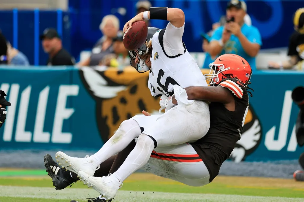Cleveland Browns defensive end Alex Wright (91) sacks Jacksonville Jaguars quarterback Trevor Lawrence (16) in the end zone for a safety during the fourth quarter of an NFL football matchup Sunday, Se...