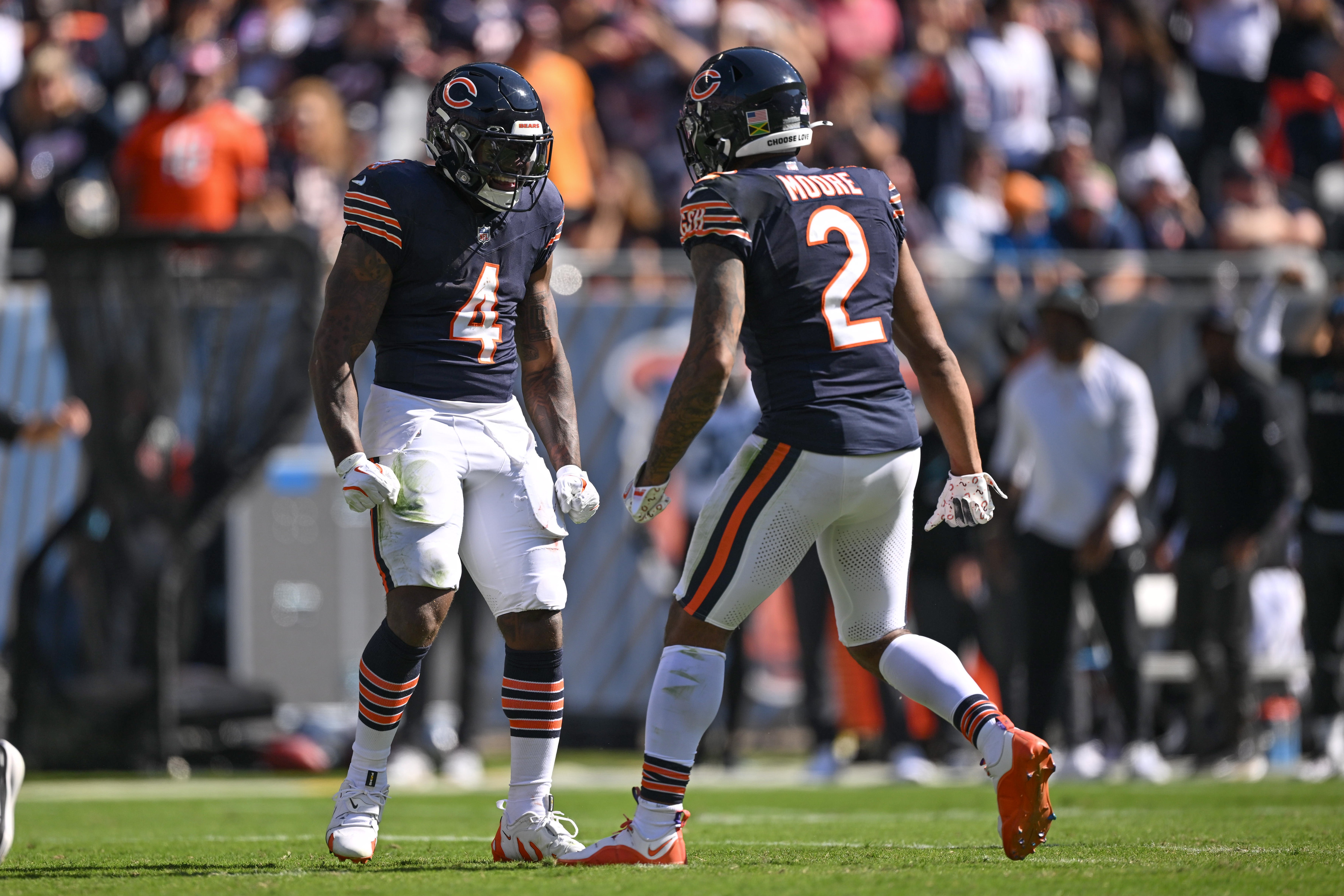 Oct 6, 2024; Chicago, Illinois, USA; Chicago Bears running back D'Andre Swift (4) celebrates a long run with wide receiver DJ Moore (2) against the Carolina Panthers during the second quarter at Soldier Field.