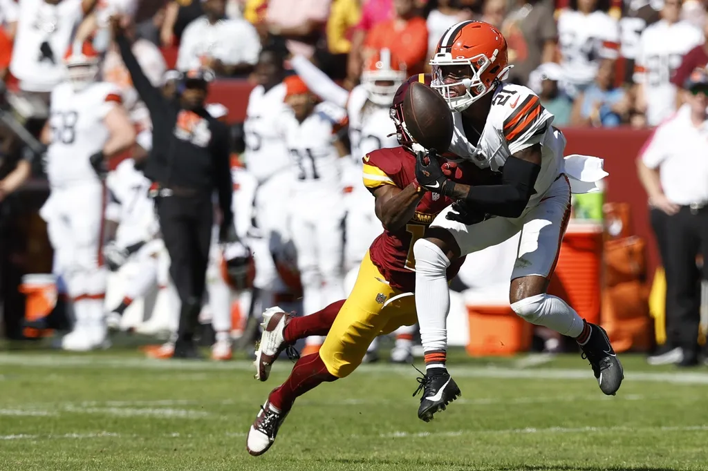 Cleveland Browns cornerback Denzel Ward (21) breaks up a pass intended for Washington Commanders wide receiver Terry McLaurin (17) during the second quarter at NorthWest Stadium.