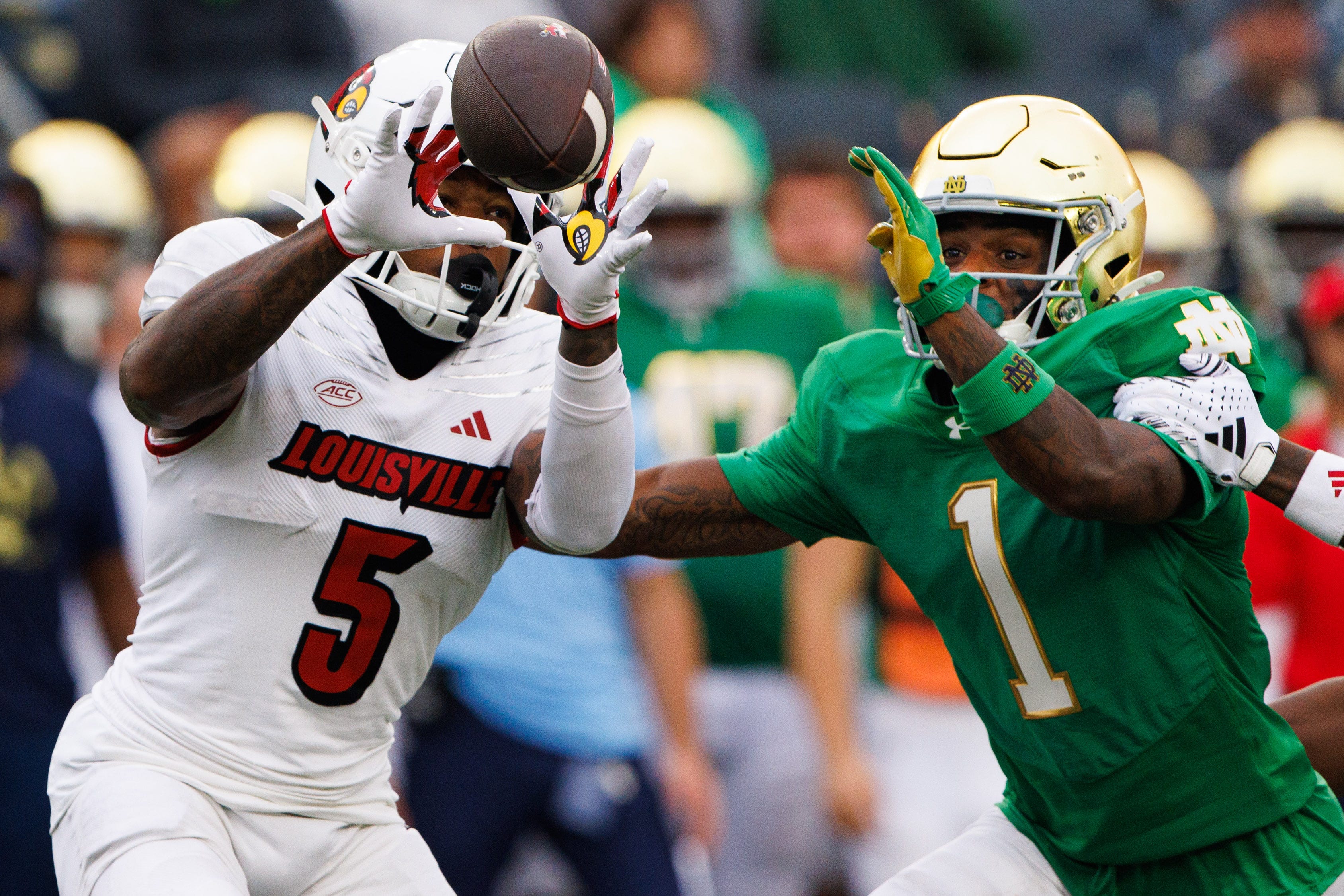 Notre Dame safety Jordan Clark (1) disrupts a catch and tackles Louisville wide receiver Caullin Lacy (5) during a NCAA college football game between Notre Dame and Louisville.