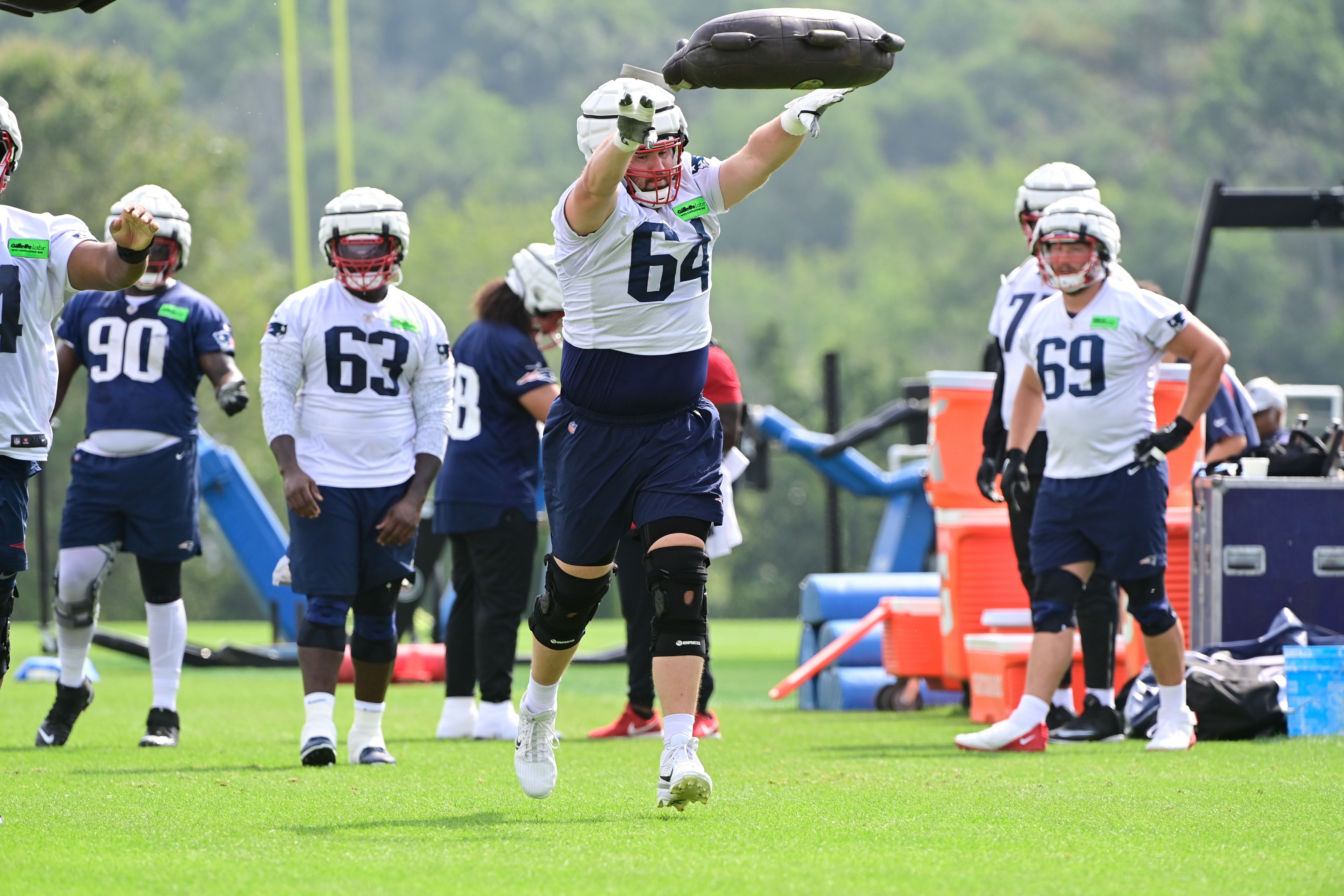 Jul 27, 2023; Foxborough, MA, USA; New England Patriots guard Andrew Stueber (64) throws a weight bag during training camp at Gillette Stadium.