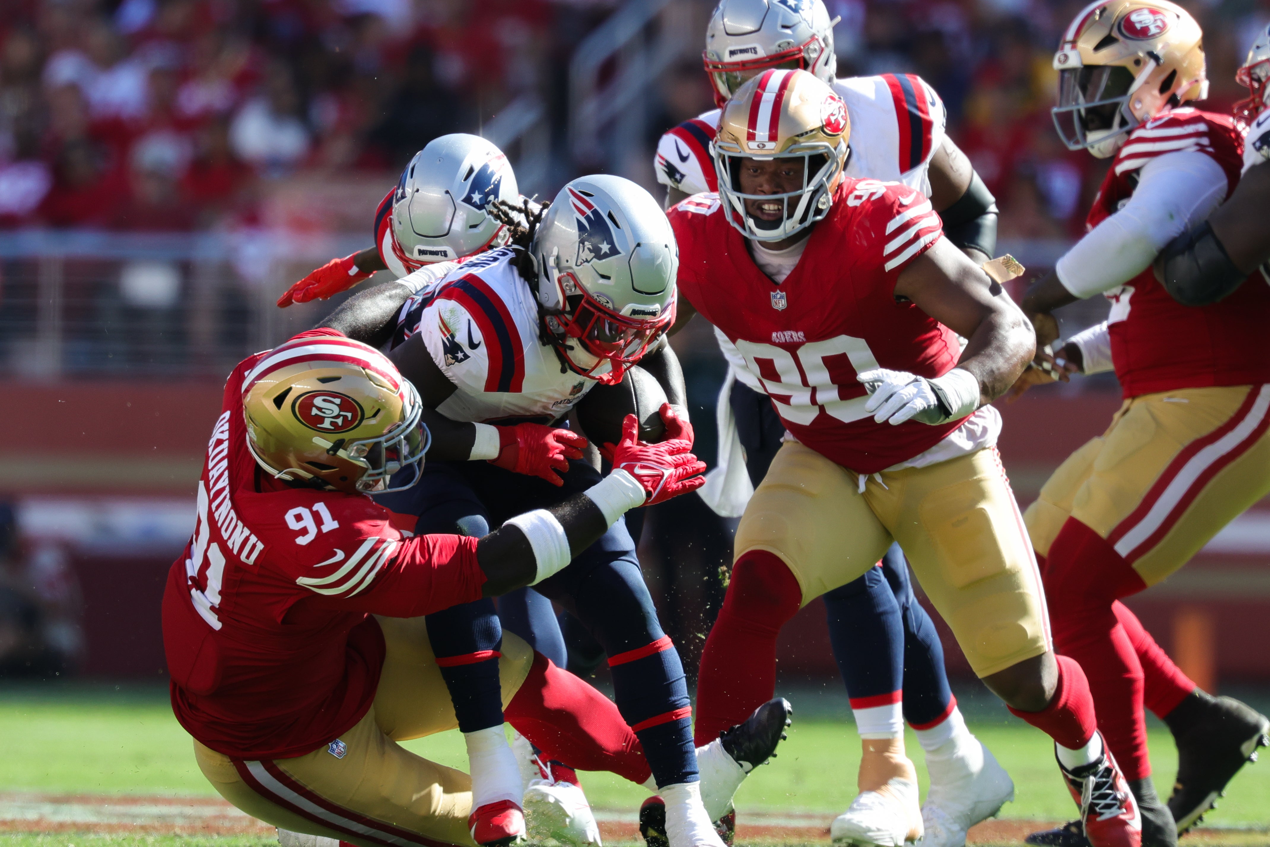 New England Patriots running back Rhamondre Stevenson (38) is tackled by San Francisco 49ers defensive tackle Sam Okuayinonu (91) during the fourth quarter at Levi's Stadium.