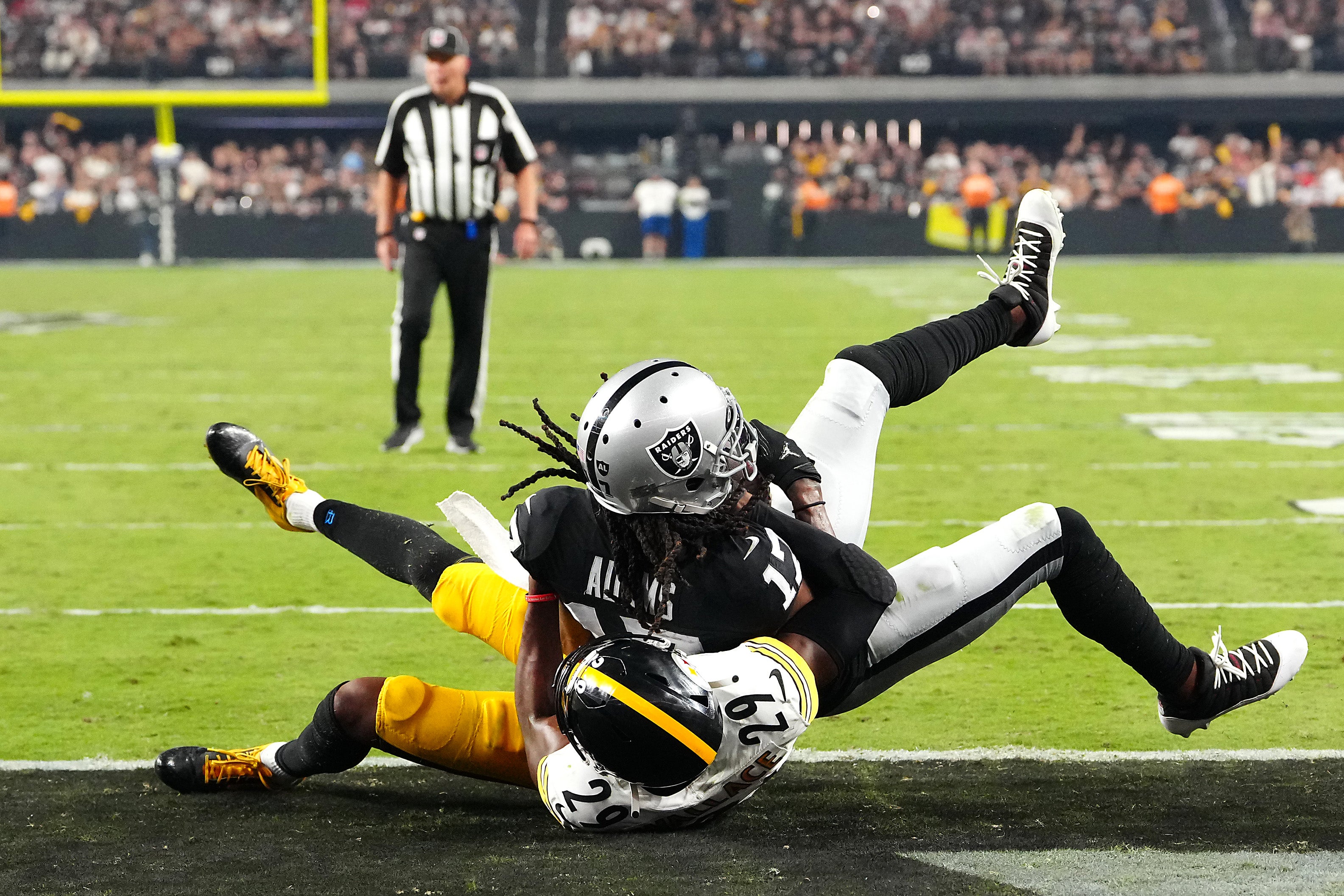 Sep 24, 2023; Paradise, Nevada, USA; Las Vegas Raiders wide receiver Davante Adams (17) scores a touchdown as Pittsburgh Steelers cornerback Levi Wallace (29) defends during the fourth quarter at Allegiant Stadium.
