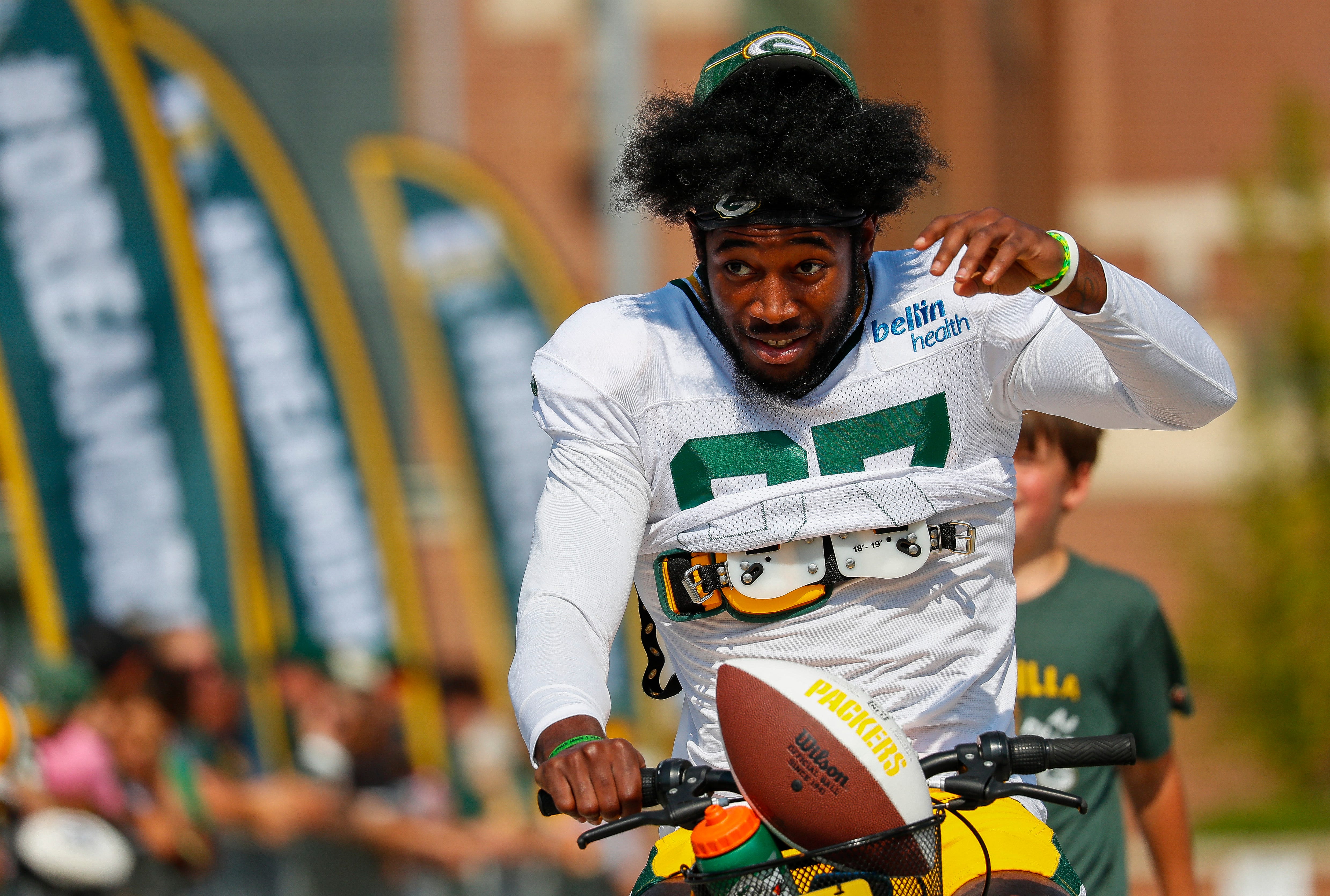 Green Bay Packers wide receiver Romeo Doubs (87) rides a bicycle to practice in the DreamDrive before the eighth practice of training camp on Wednesday, July 31, 2024, at Lambeau Field in Green Bay, Wis.