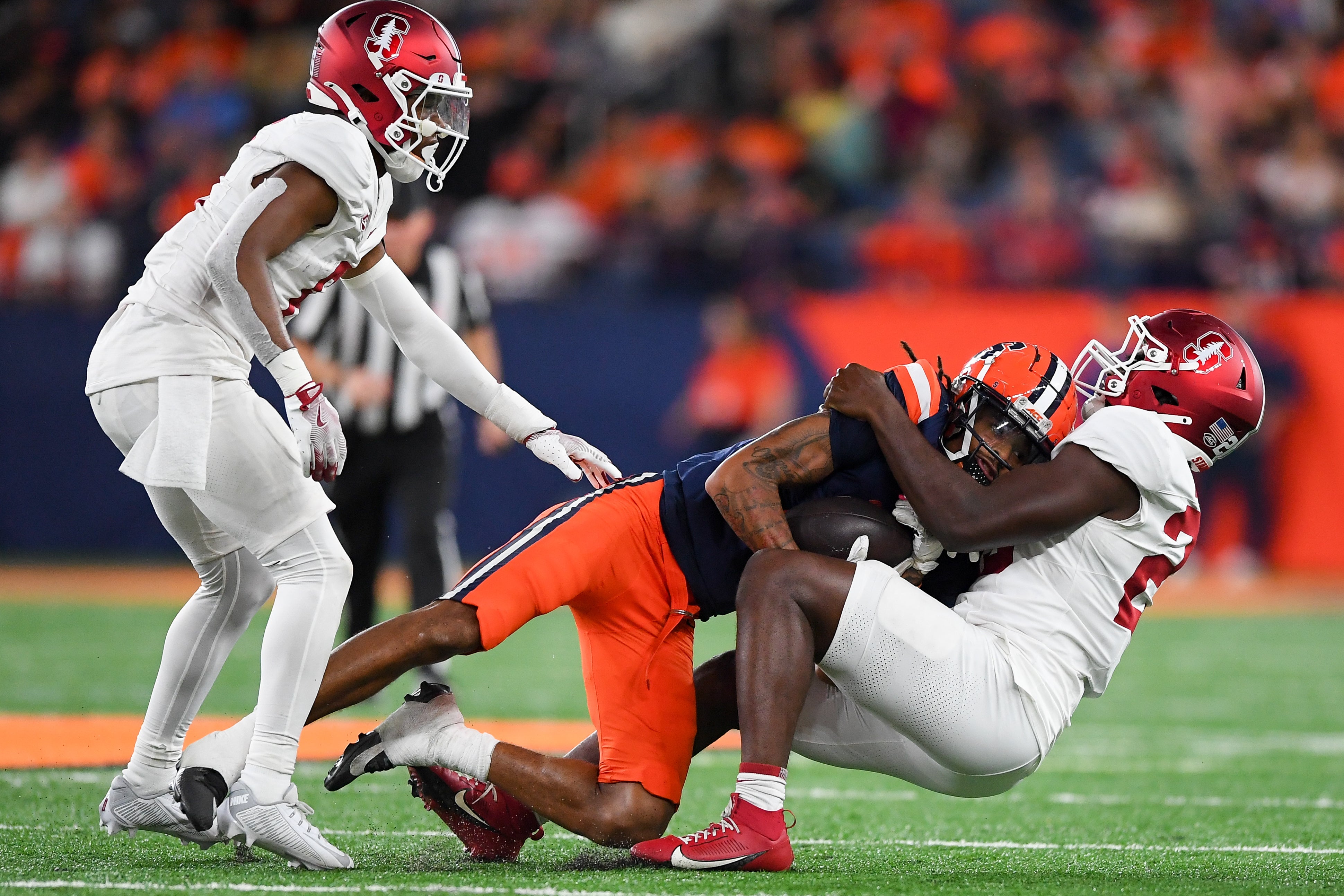 Stanford Cardinal linebacker David Bailey (right) tackles Syracuse Orange wide receiver Umari Hatcher (5) as cornerback Collin Wright (6) looks on during the second half at the JMA Wireless Dome.