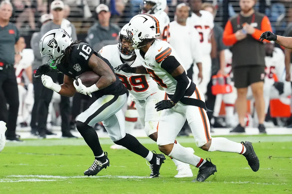 Las Vegas Raiders wide receiver Jakobi Meyers (16) gains yardage between Cleveland Browns linebacker Khaleke Hudson (39) and Cleveland Browns safety Grant Delpit (9) during the third quarter