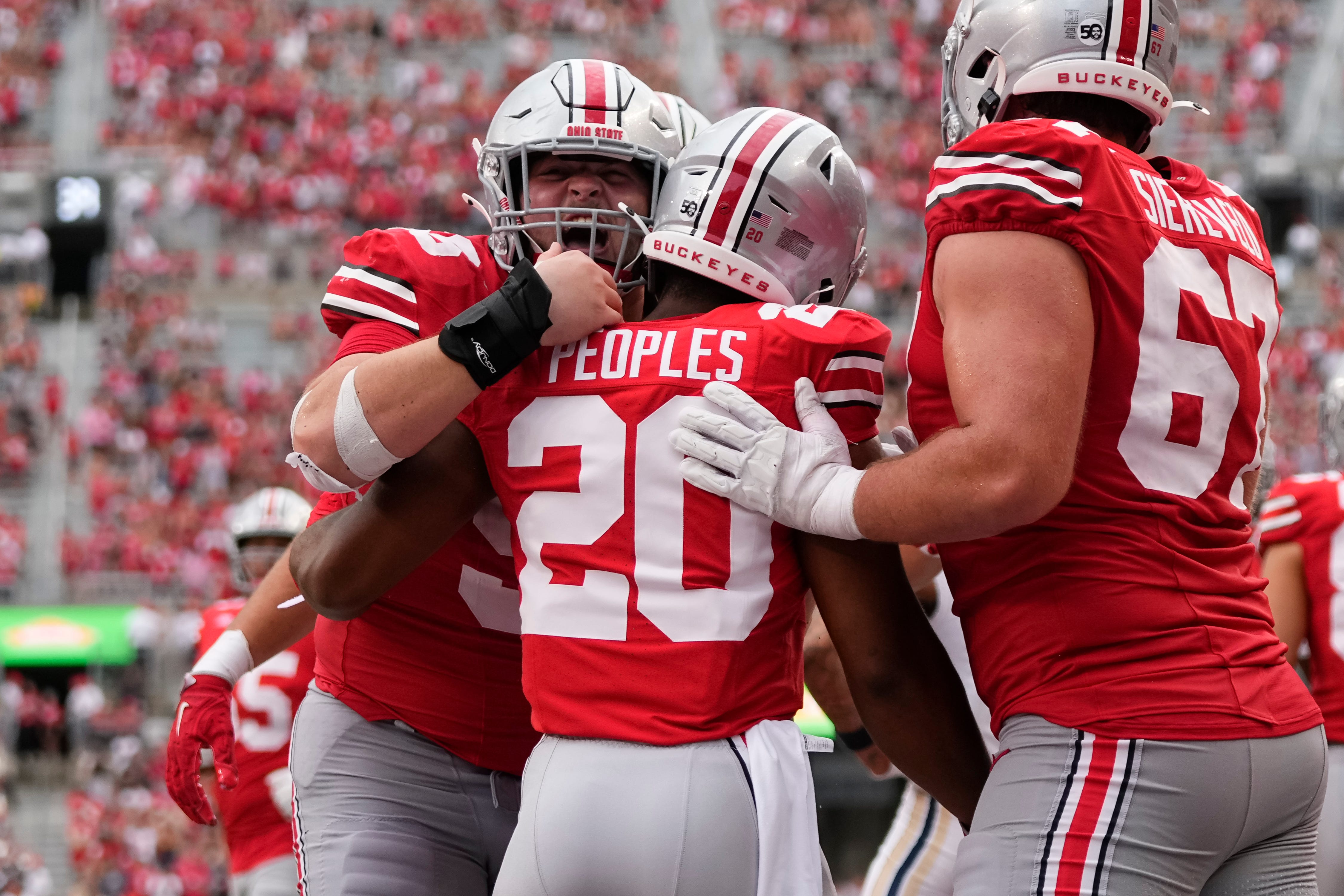 Ohio State Buckeyes running back James Peoples (20) celebrates a touchdown with offensive linemen Seth McLaughlin (56) and Austin Siereveld (67) during the second half of the NCAA football game against the Akron Zips at Ohio Stadium.