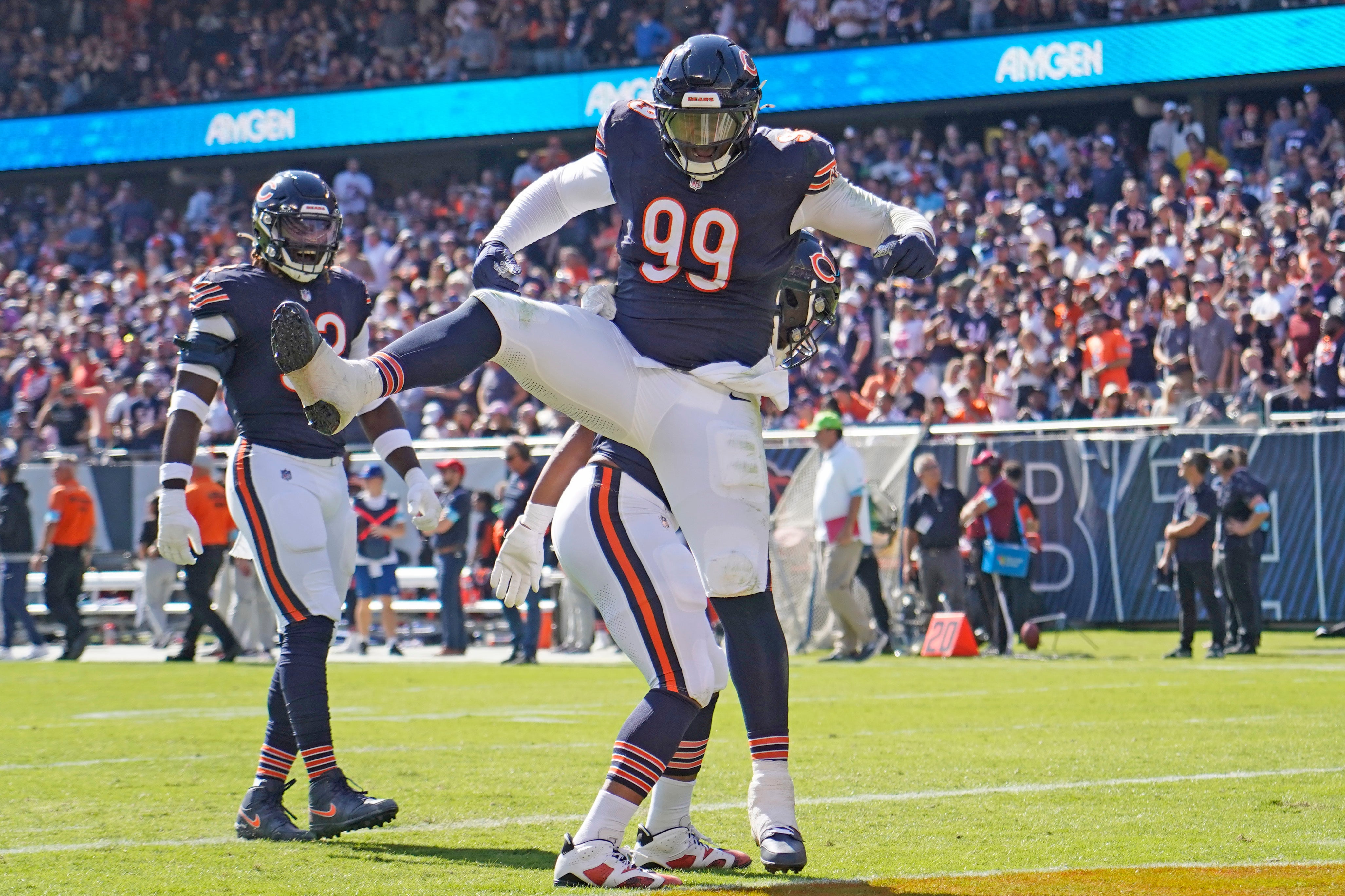 Oct 6, 2024; Chicago, Illinois, USA; Chicago Bears defensive tackle Gervon Dexter Sr. (99) and defensive end DeMarcus Walker (95) celebrate a fumble recovery against the Carolina Panthers during the first half at Soldier Field.