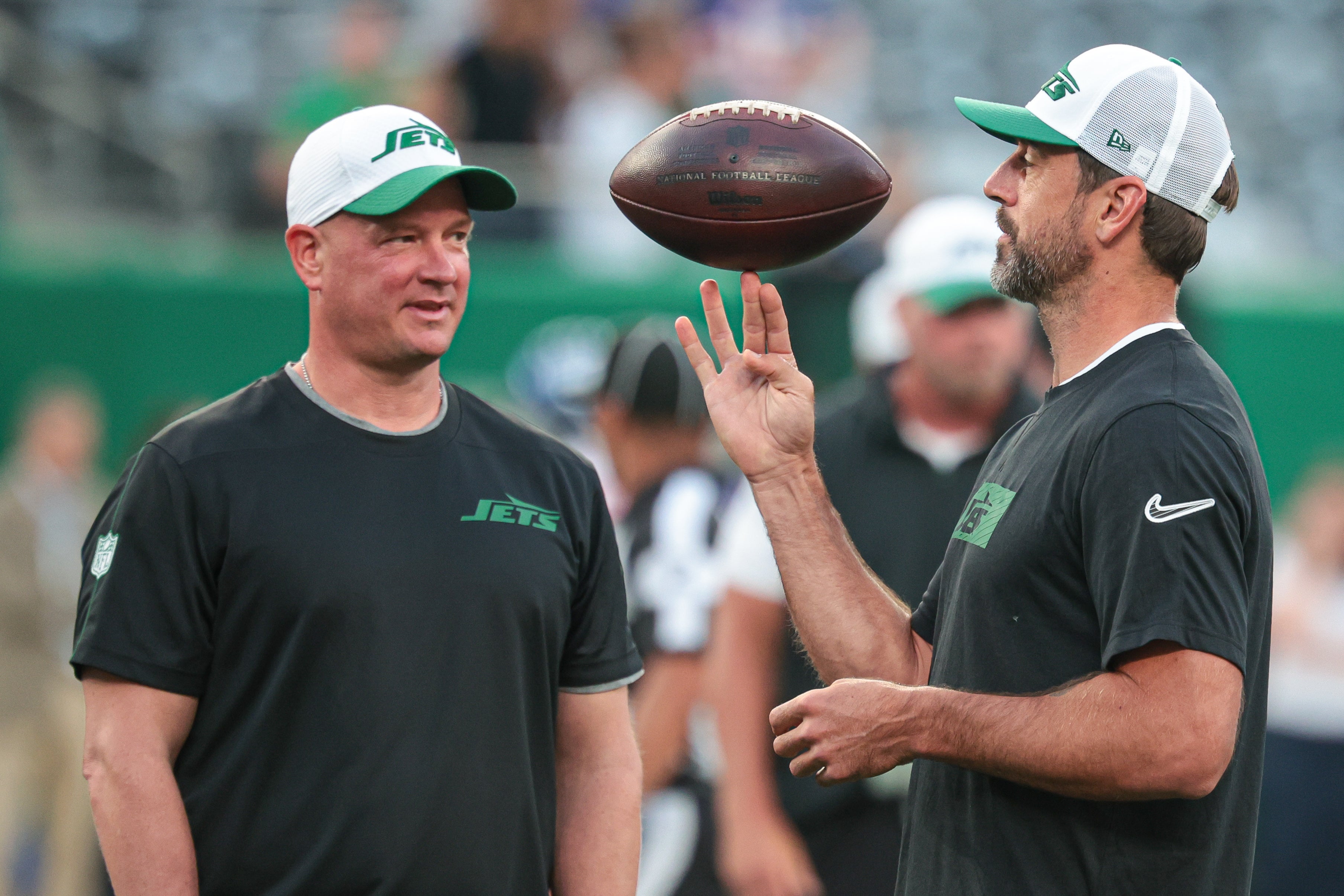 New York Jets quarterback Aaron Rodgers (left) spins the ball in front of offensive coordinator Nathaniel Hackett before the game against the New York Giants at MetLife Stadium.