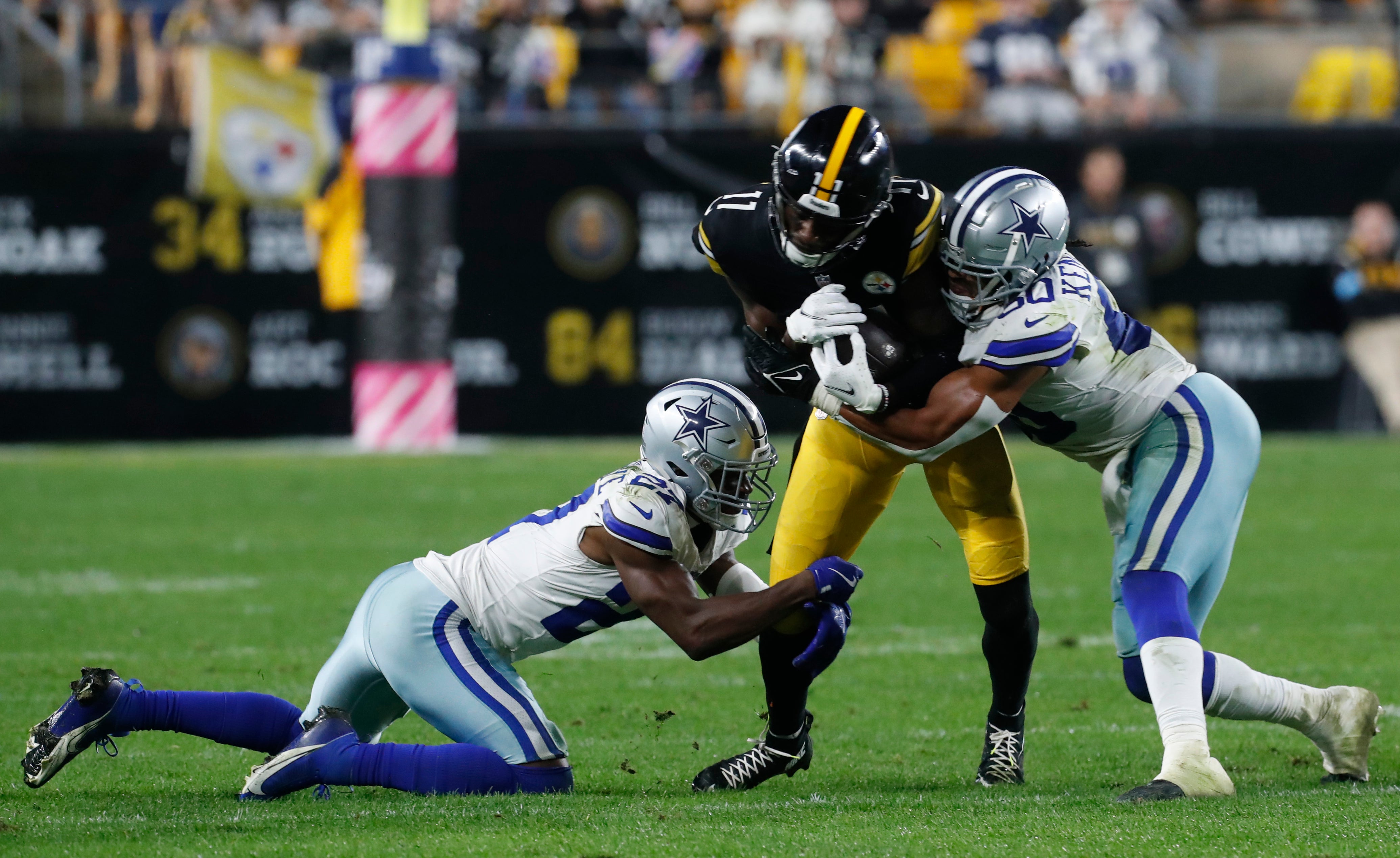 Pittsburgh Steelers wide receiver Van Jefferson (11) runs after a catch as Dallas Cowboys cornerback Amani Oruwariye (27) and linebacker Eric Kendricks (50) tackle during the fourth quarter at Acrisure Stadium.