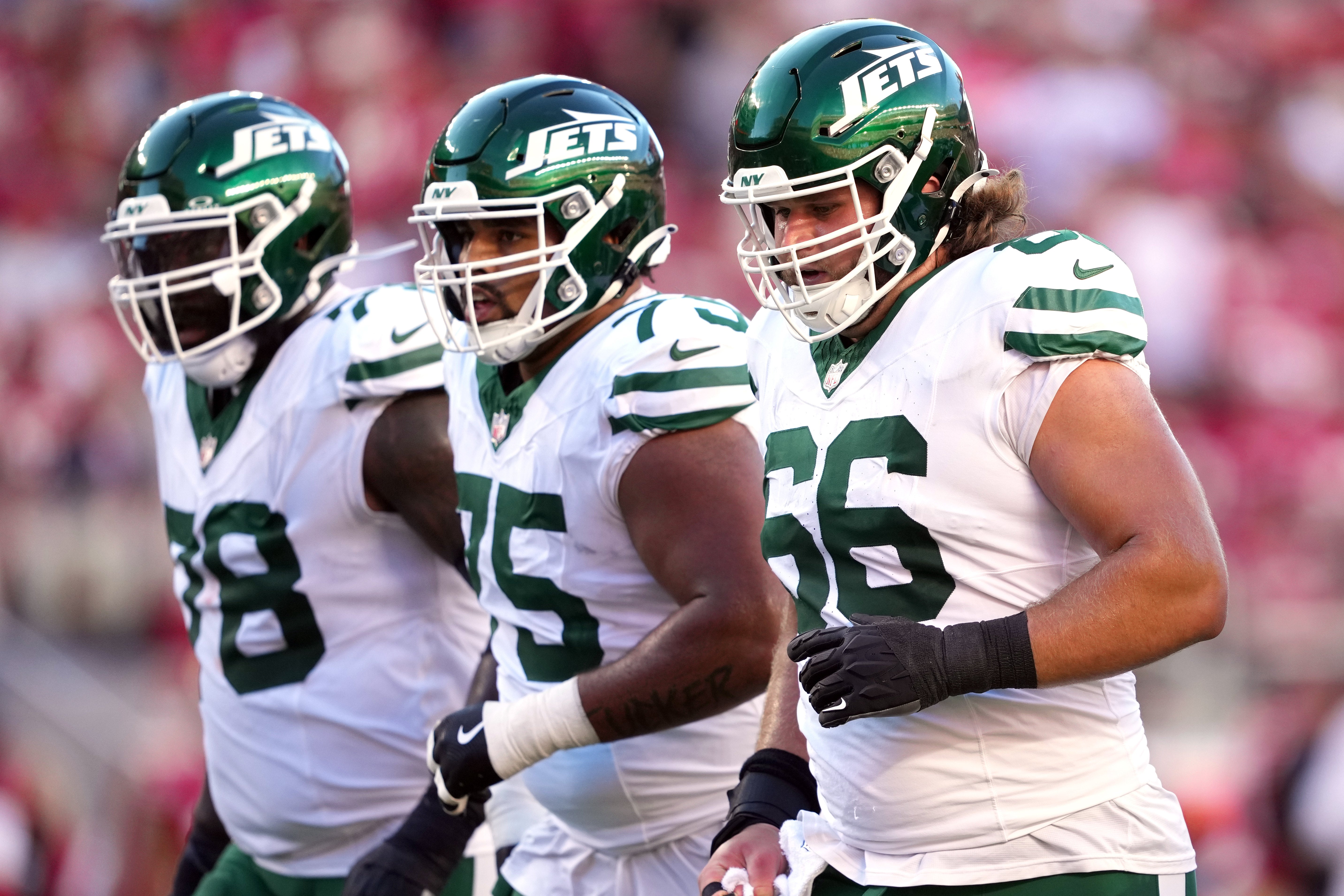 New York Jets center Joe Tippmann (66) walks to the line of scrimmage with offensive tackle Morgan Moses (left) and guard Alijah Vera-Tucker (center) during the first quarter against the San Francisco 49ers at Levi's Stadium.