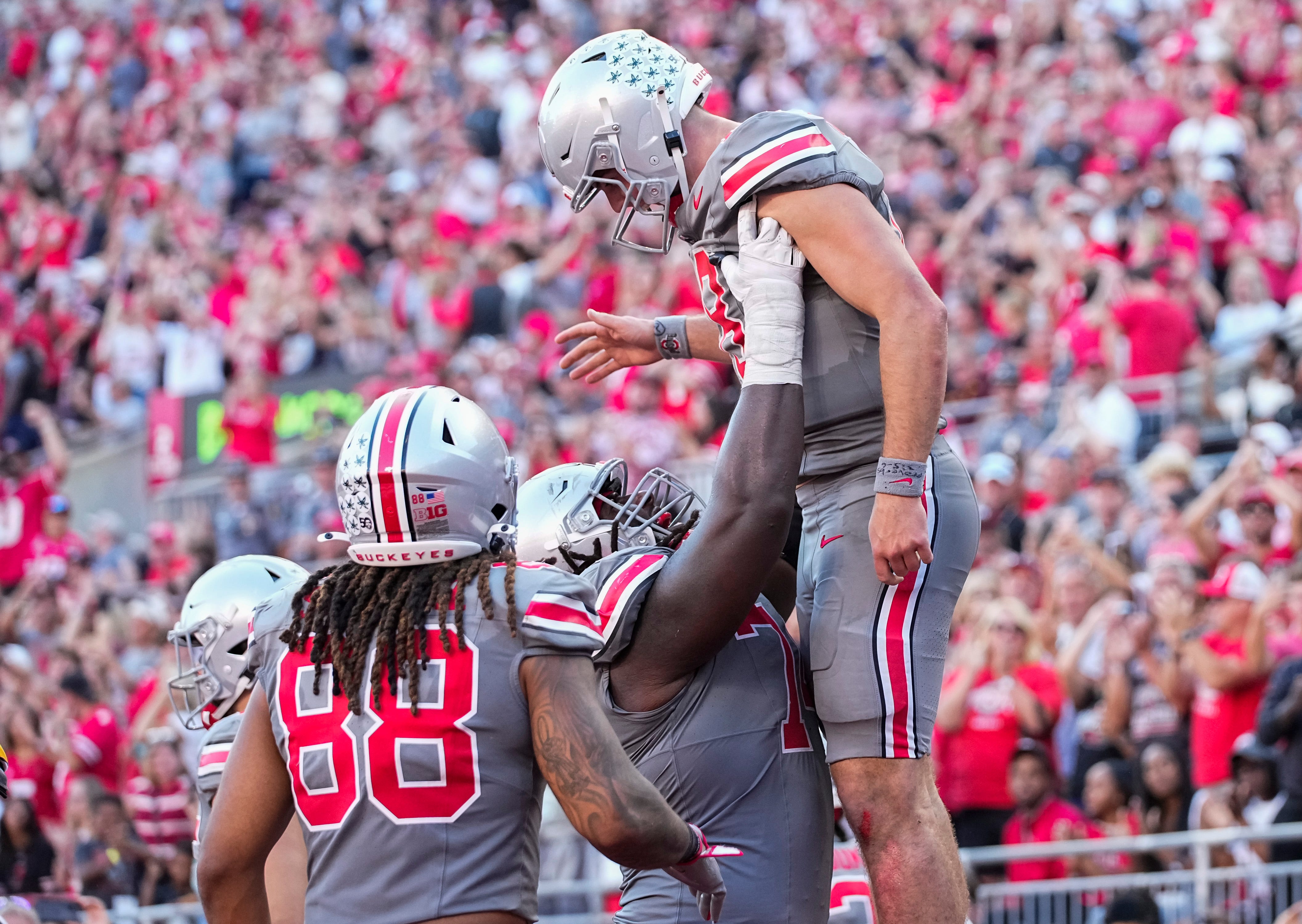 Ohio State Buckeyes quarterback Will Howard (18) celebrates a touchdown with offensive lineman Donovan Jackson (74) and tight end Gee Scott Jr. (88) during the second half of the NCAA football game at Ohio Stadium.
