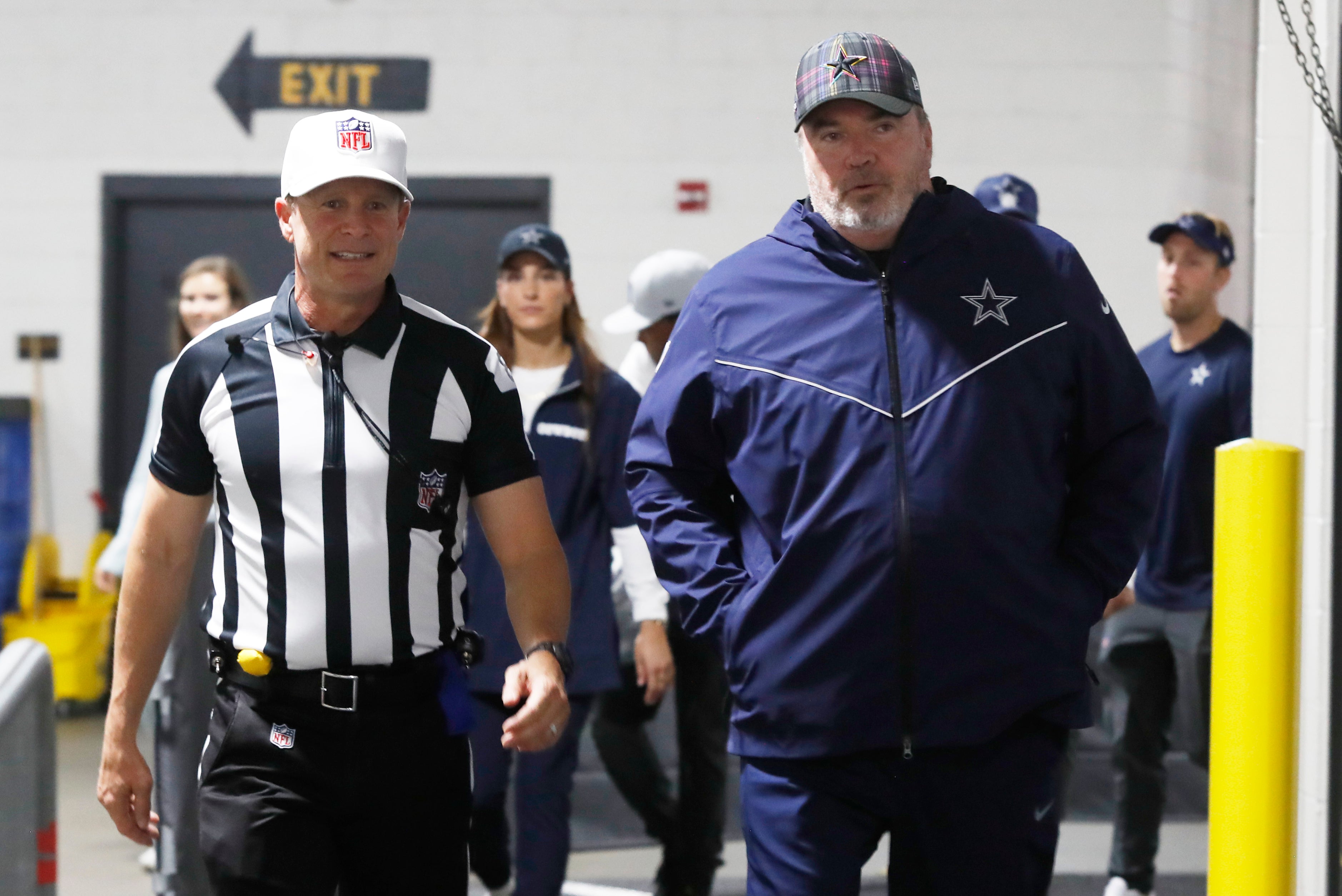 NFL referee Shawn Hochuli (left) and Dallas Cowboys head coach Mike McCarthy (right) return to the locker room after warming up against the Pittsburgh Steelers at Acrisure Stadium.