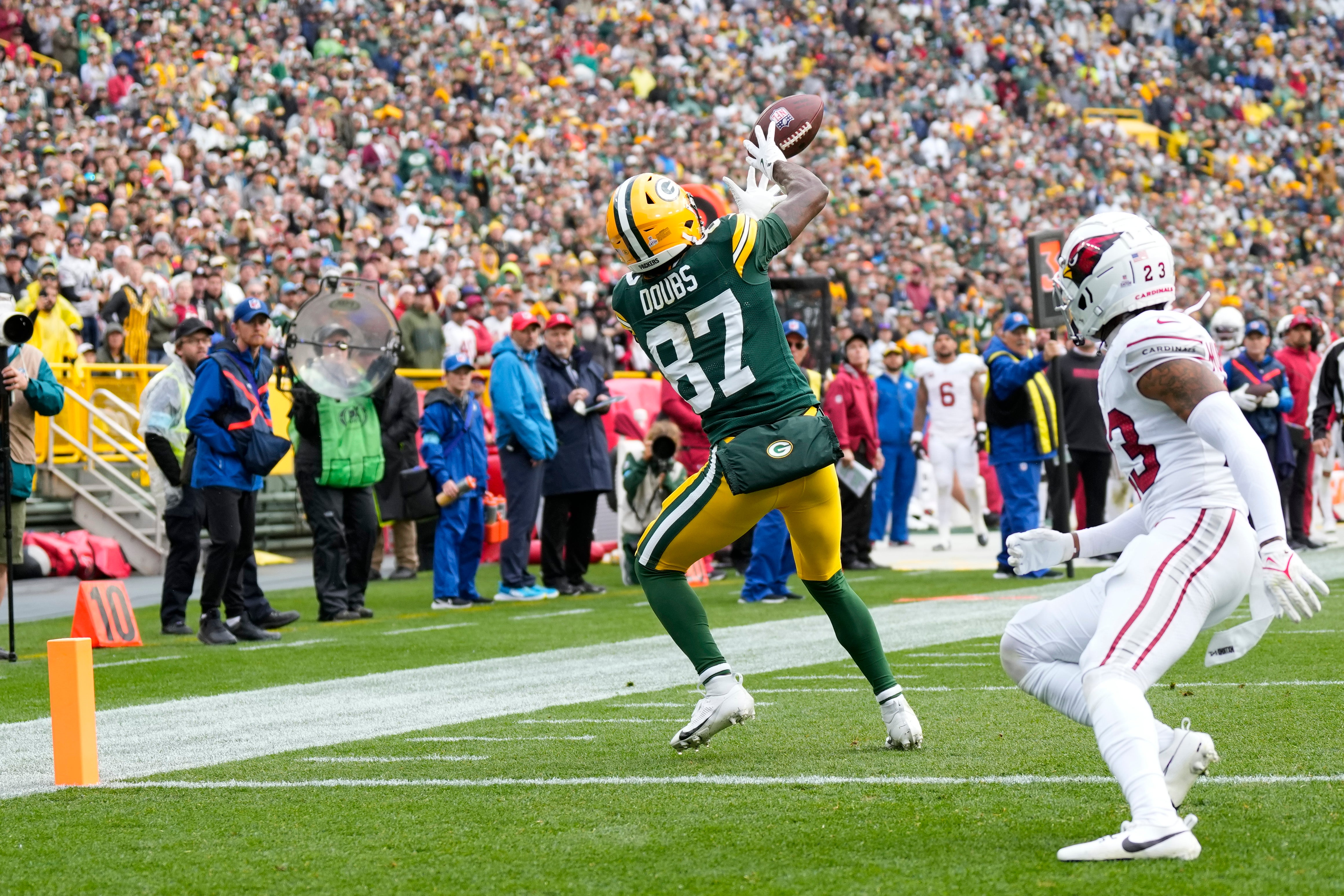 Green Bay Packers wide receiver Romeo Doubs (87) catches a pass before scoring a touchdown in front of Arizona Cardinals cornerback Sean Murphy-Bunting (23) during the third quarter at Lambeau Field.