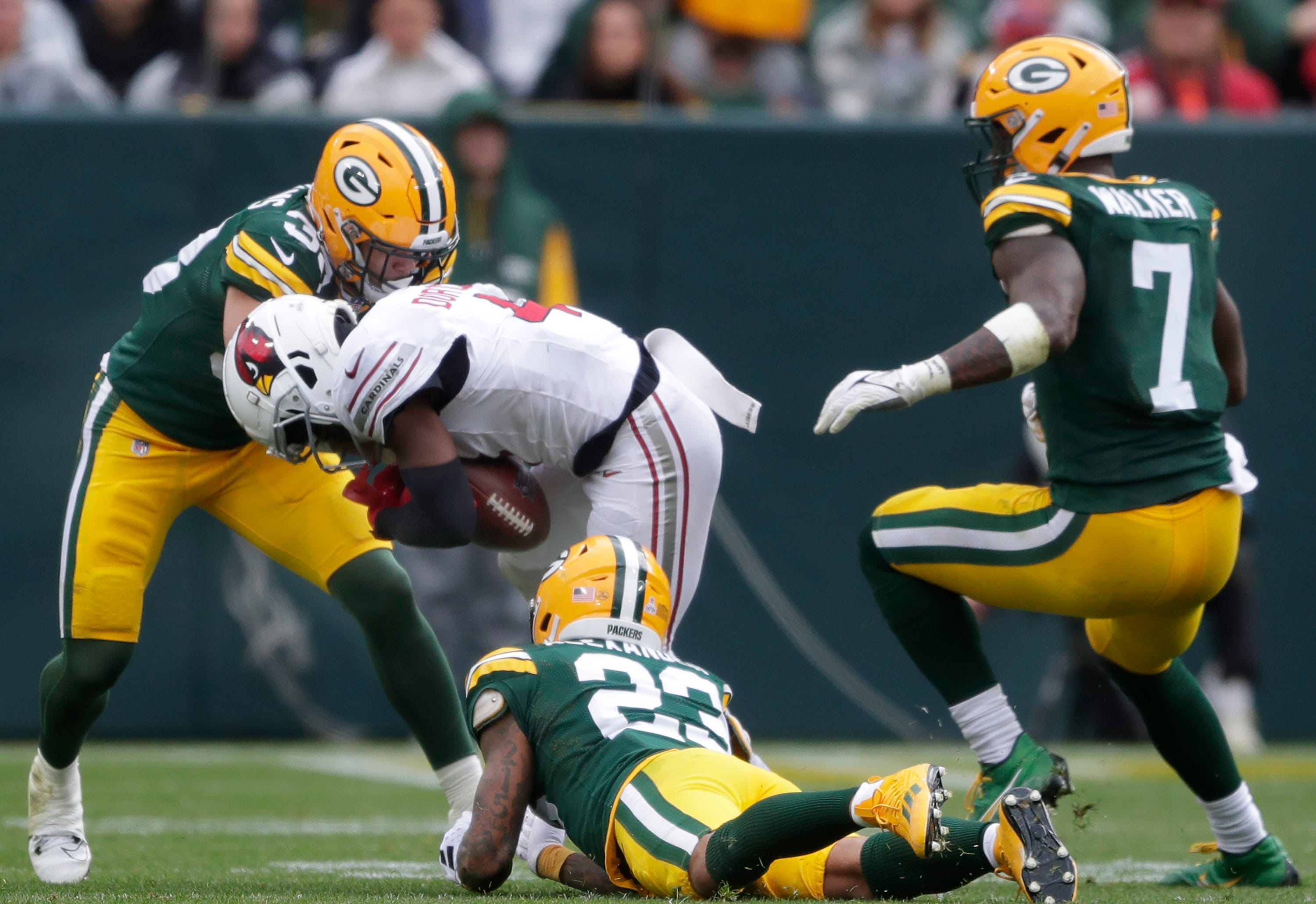 Green Bay Packers safety Evan Williams (33) knocks the ball loose while tackling Arizona Cardinals wide receiver Greg Dortch (4) on Sunday, October 13, 2024 at Lambeau Field in Green Bay, Wis. The Packers defeated the Cardinals 34-13.