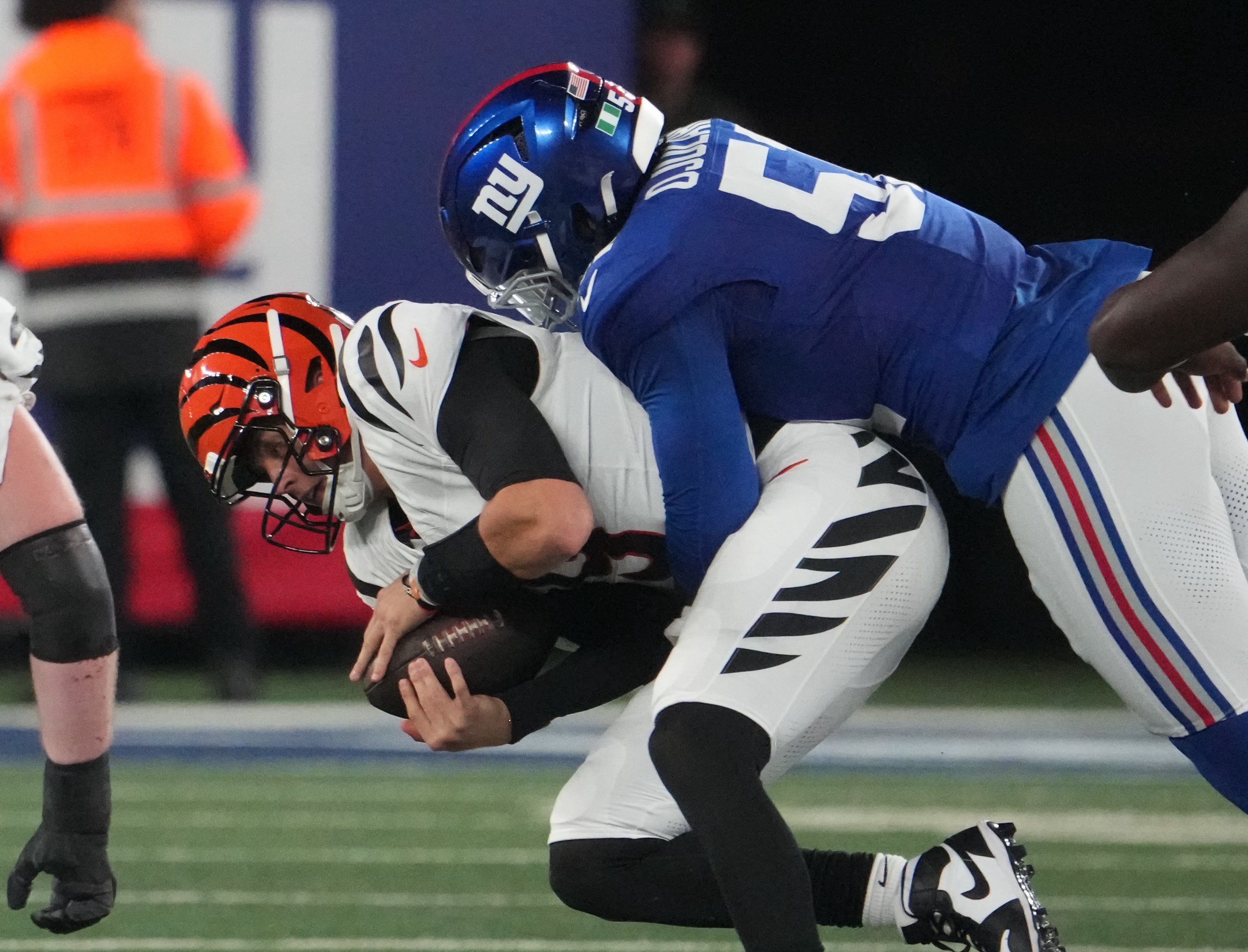 Oct 13, 2024; East Rutherford, New Jersey, USA; New York Giants linebacker Azeez Ojulari (51) tackles Cincinnati Bengals quarterback Joe Burrow (9) during the first half at MetLife Stadium.
