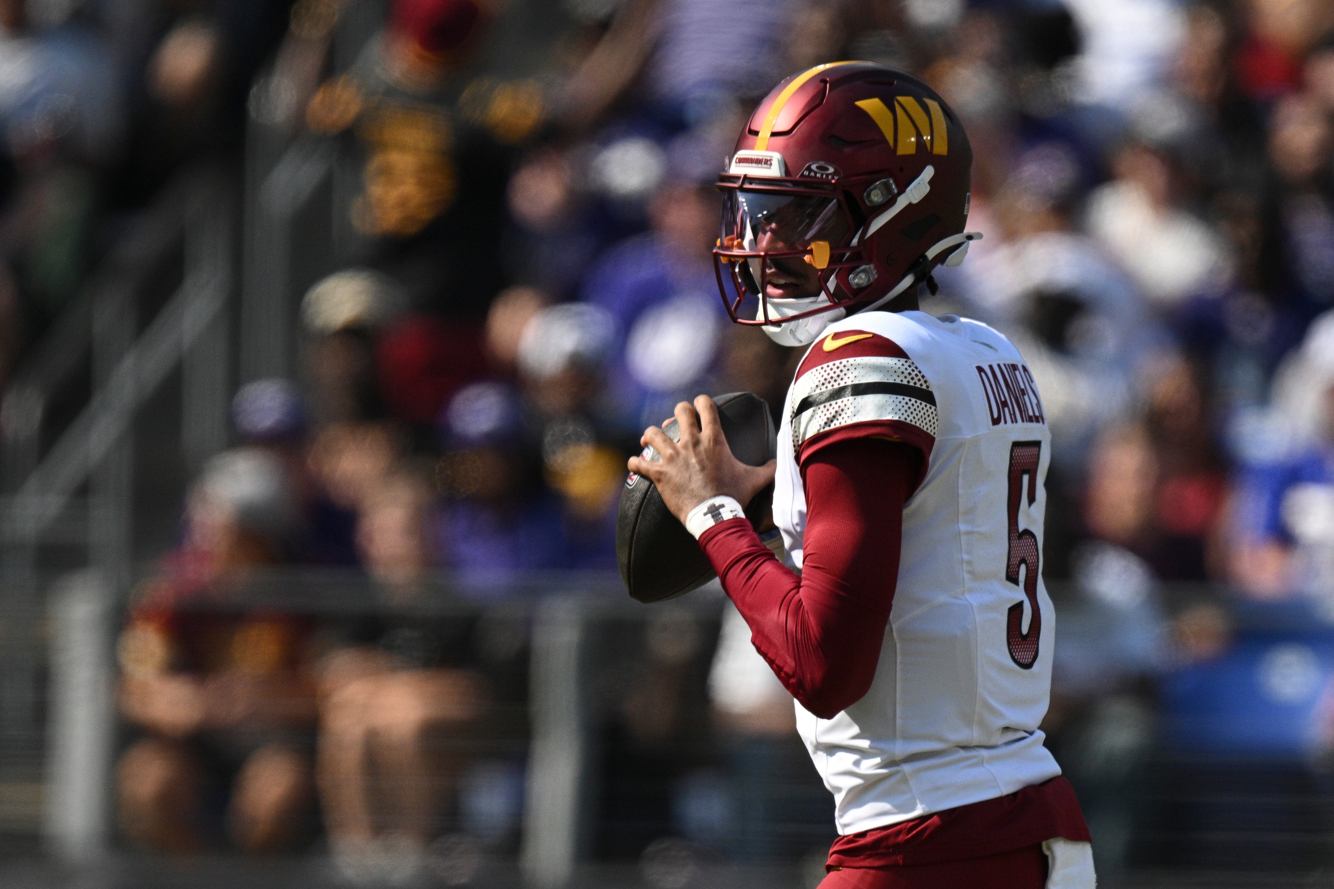 Oct 13, 2024; Baltimore, Maryland, USA; Washington Commanders quarterback Jayden Daniels (5) loos to throws during the first quarter against the Baltimore Ravens at M&T Bank Stadium.