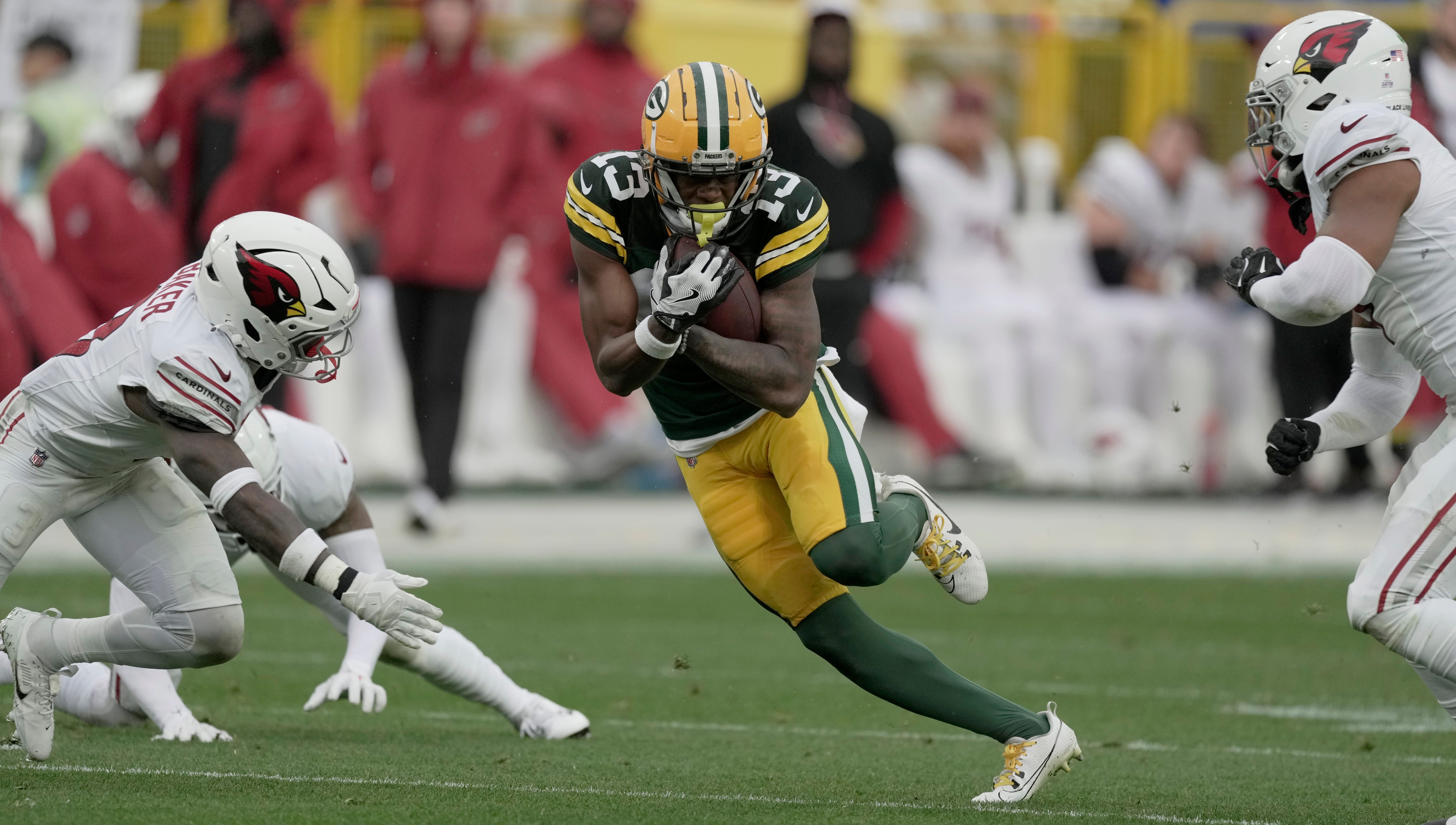 Green Bay Packers wide receiver Dontayvion Wicks (13) find a seam in the Arizona Cardinals defense during the first quarter of their game against the Arizona Cardinals Sunday, October 13, 2024 at Lambeau Field in Green Bay, Wisconsin.