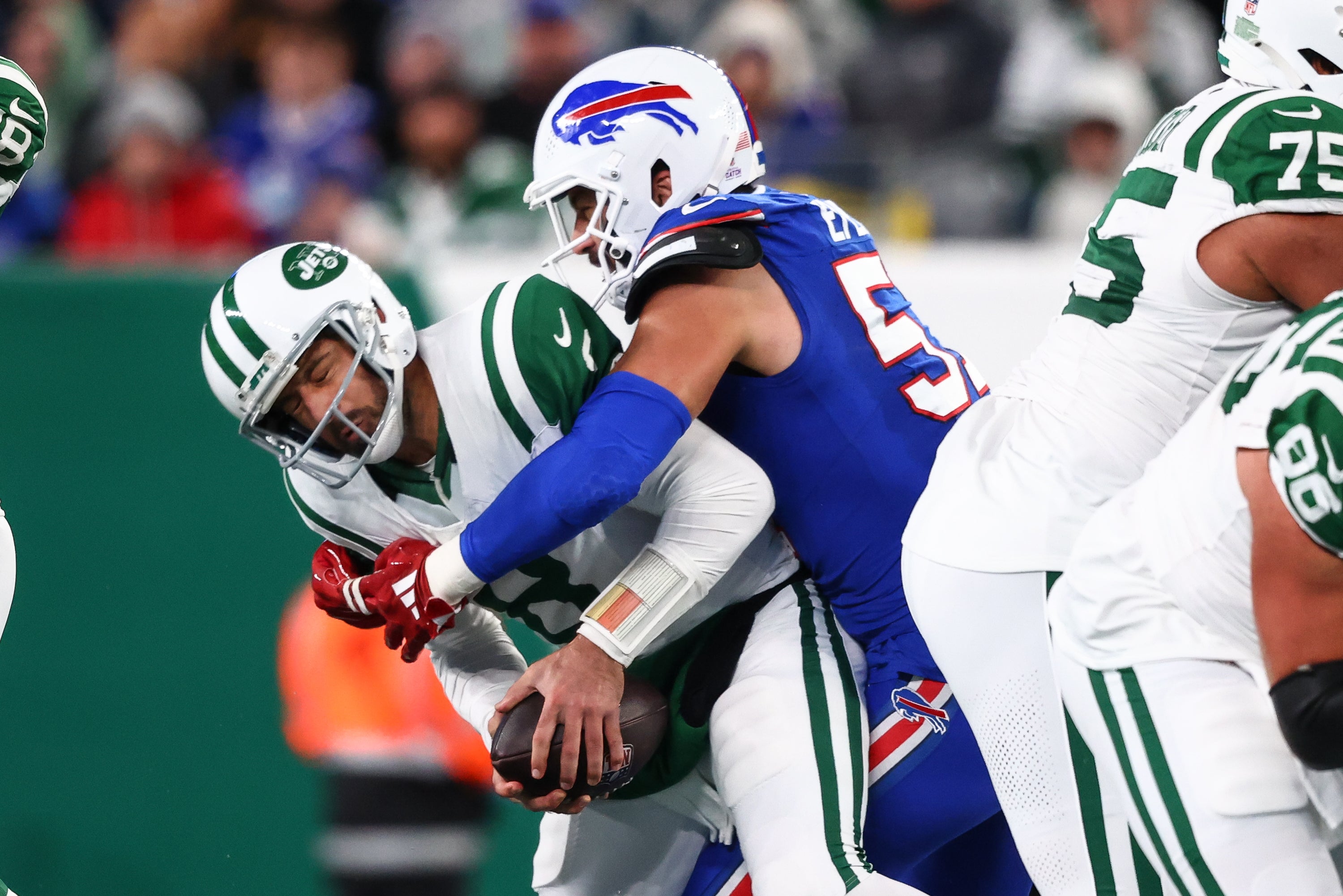 New York Jets quarterback Aaron Rodgers (8) is sacked by Buffalo Bills defensive end AJ Epenesa (57) during the first half at MetLife Stadium.