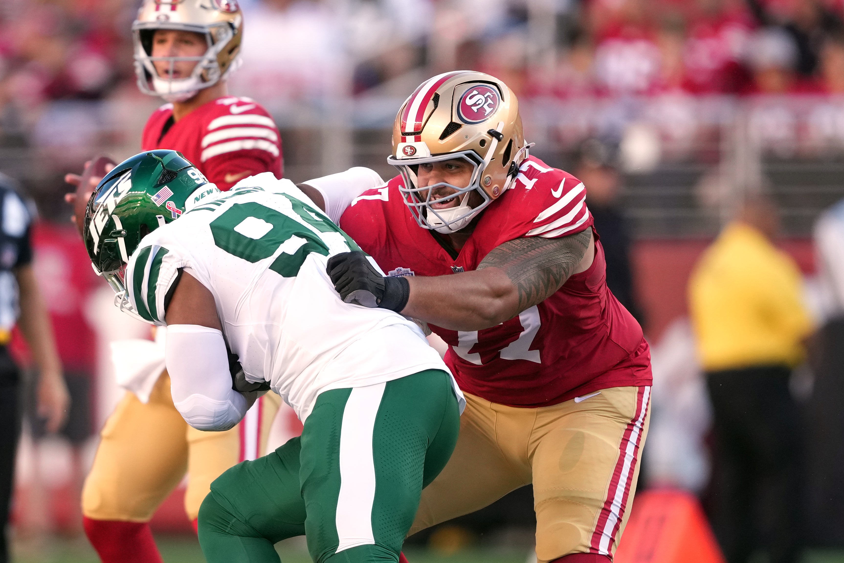San Francisco 49ers guard Dominick Puni (77) blocks New York Jets defensive end Solomon Thomas (left) during the first quarter at Levi's Stadium.