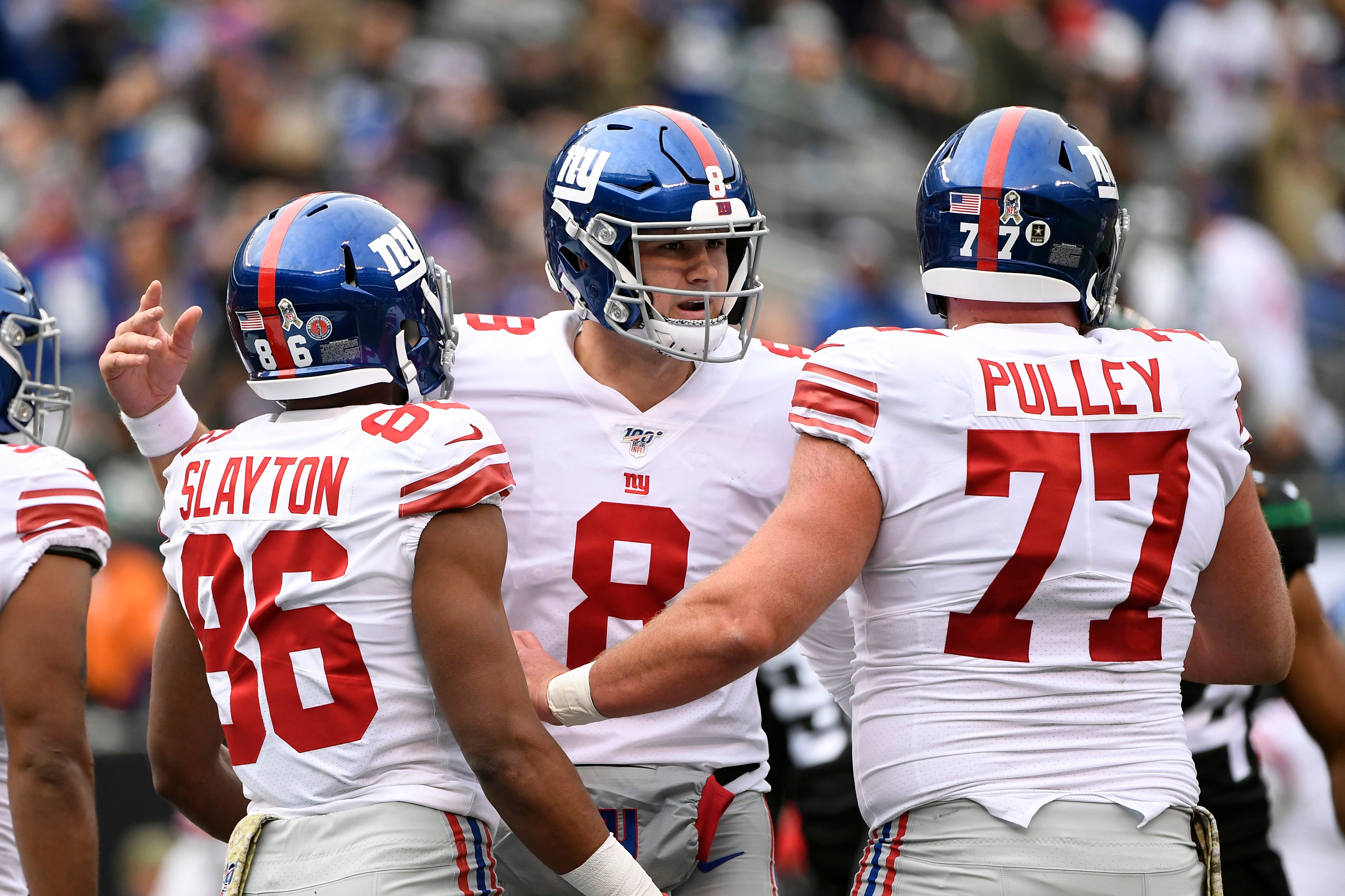 New York Giants quarterback Daniel Jones (8) celebrates Darius Slayton's (86) touchdown with center Spencer Pulley (77) in the first half. The New York Jets host the New York Giants in an NFL game on Sunday,