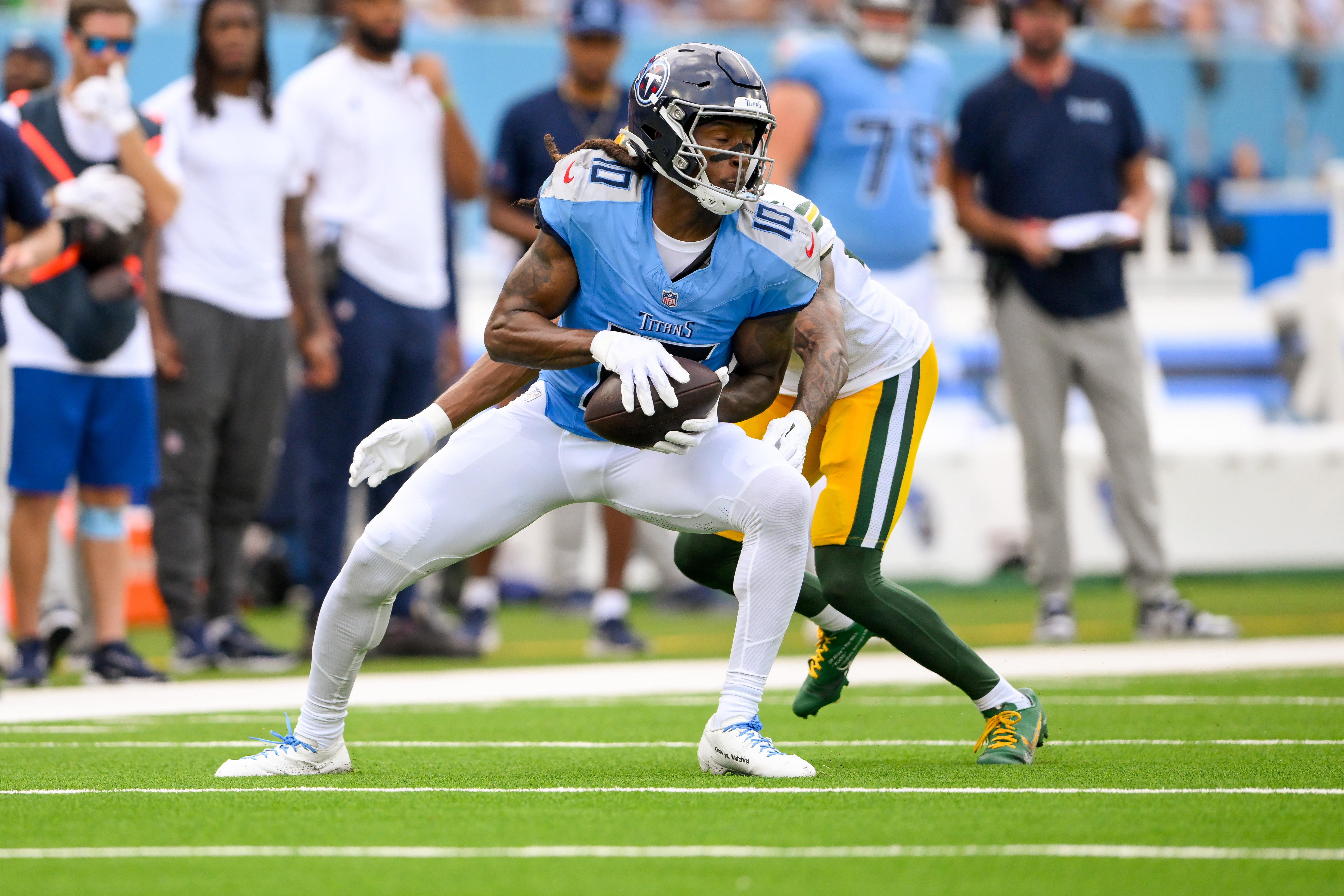 Tennessee Titans wide receiver DeAndre Hopkins (10) makes a catch as Green Bay Packers cornerback Eric Stokes (21) converses during the first half at Nissan Stadium. Steve Roberts-Imagn Images