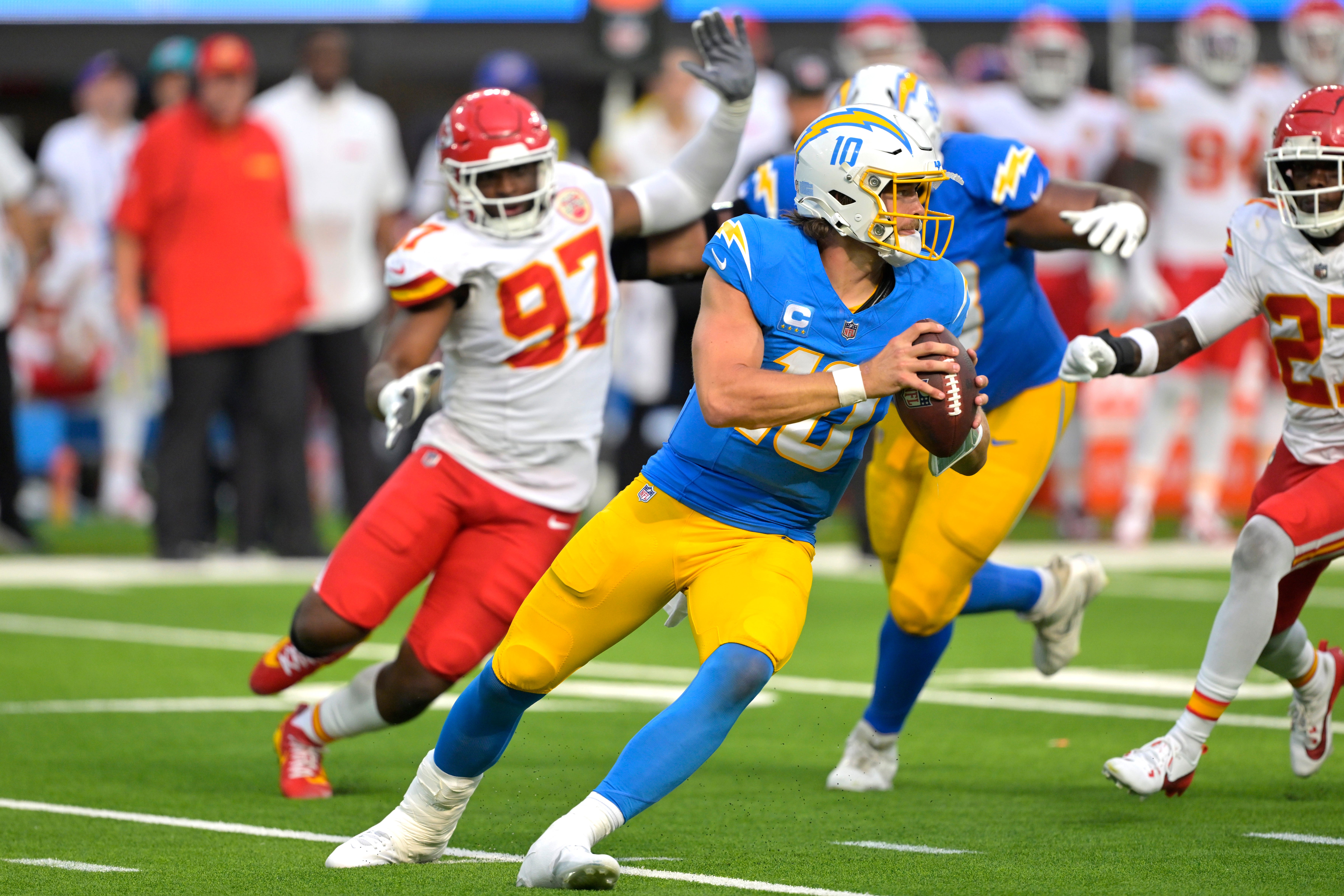 Sep 29, 2024; Inglewood, California, USA; Los Angeles Chargers quarterback Justin Herbert (10) is pressured by Kansas City Chiefs defensive end Felix Anudike-Uzomah (97) in the second half at SoFi Stadium.