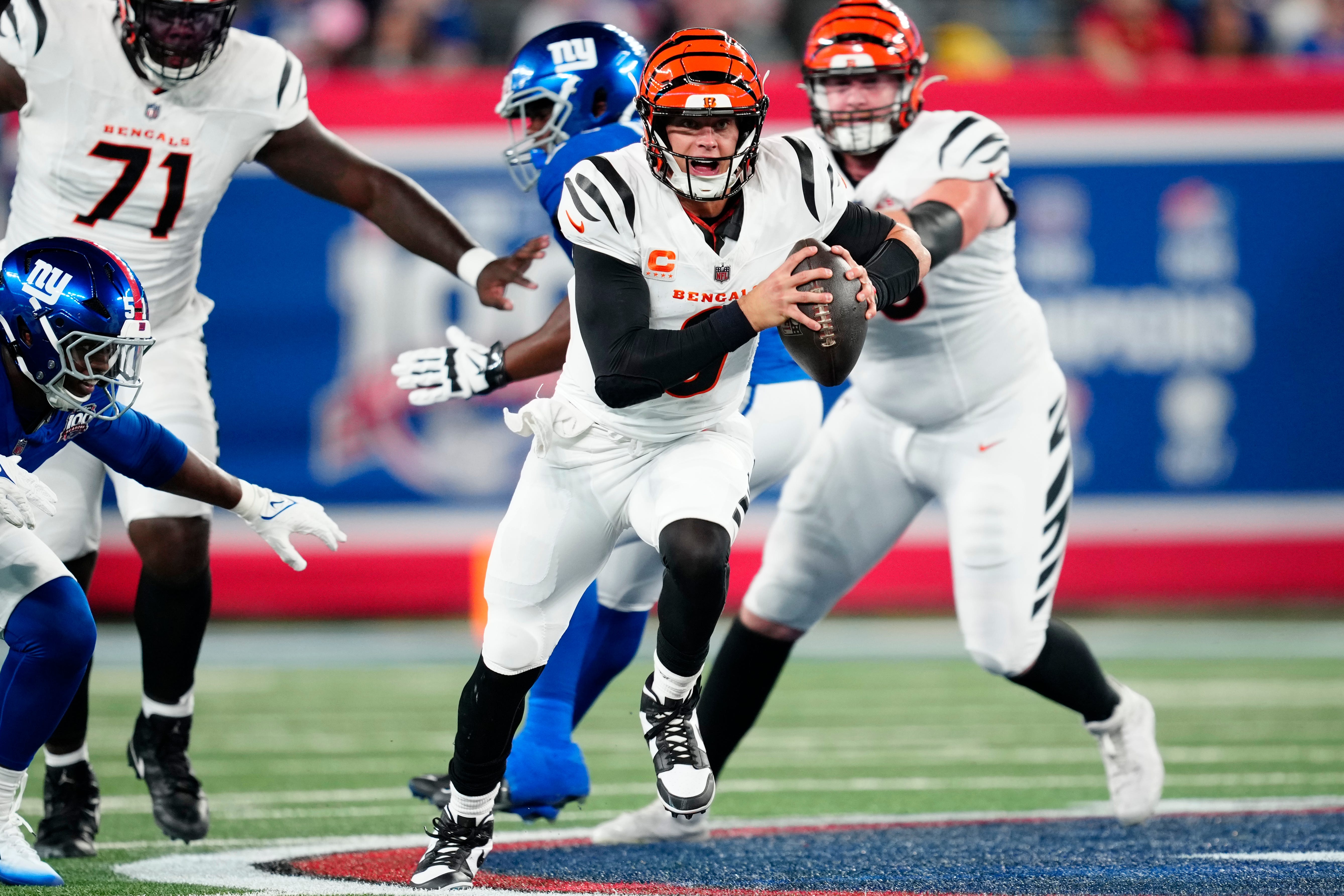 Cincinnati Bengals quarterback Joe Burrow (9) runs past the New York Giants defense as he begins his touchdown run to score the first points of the game, Sunday, October 13, 2024, in East Rutherford.