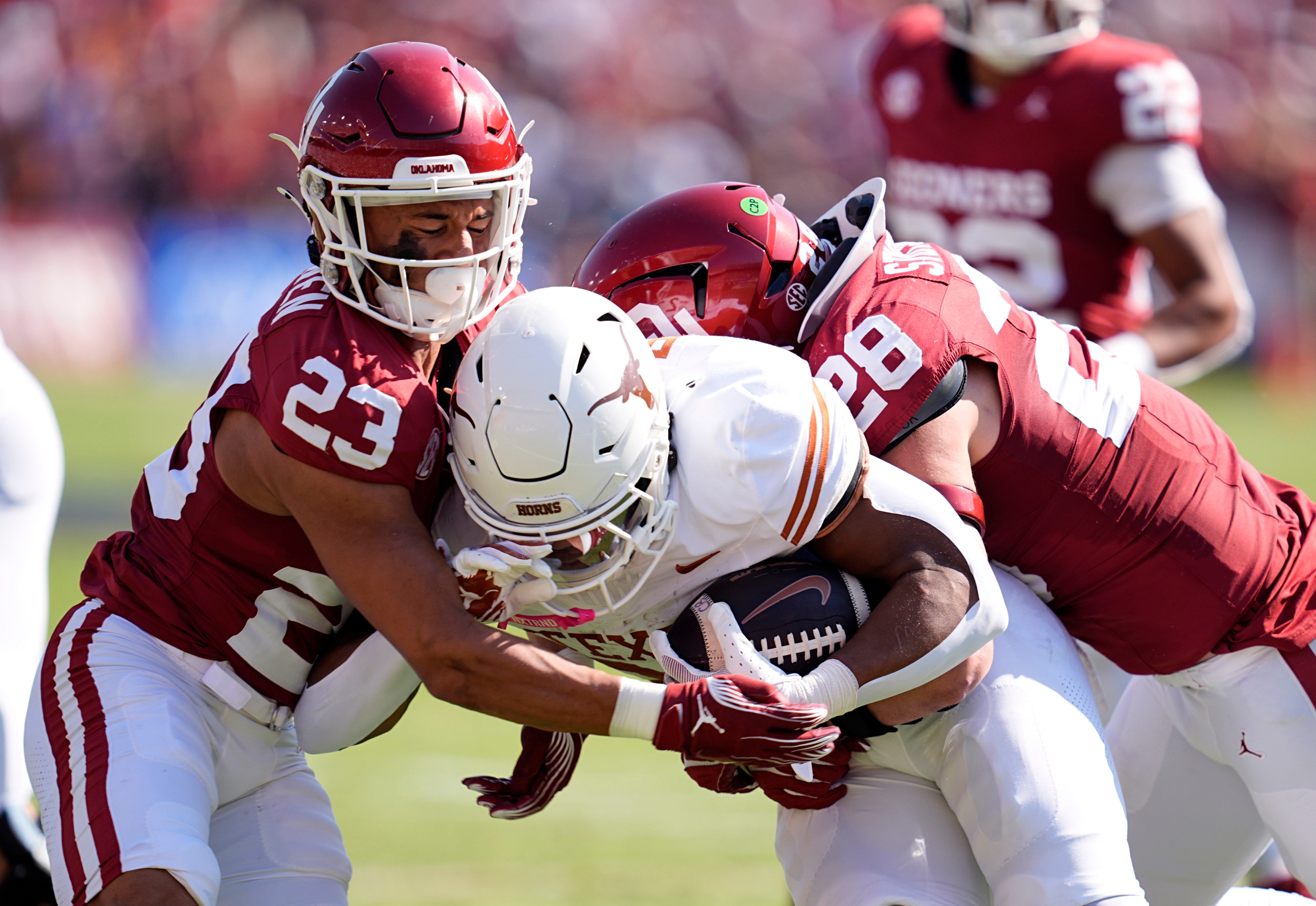 Oklahoma Sooners defensive back Eli Bowen (23) and Danny Stutsman (28) tackle Texas Longhorns running back Jaydon Blue (23) in the first half of the Red River Rivalry college football game between the University of Oklahoma Sooners and the Texas Longhorn at the Cotton Bowl Stadium in Dallas, Texas, Saturday, Oct., 12, 2024.
