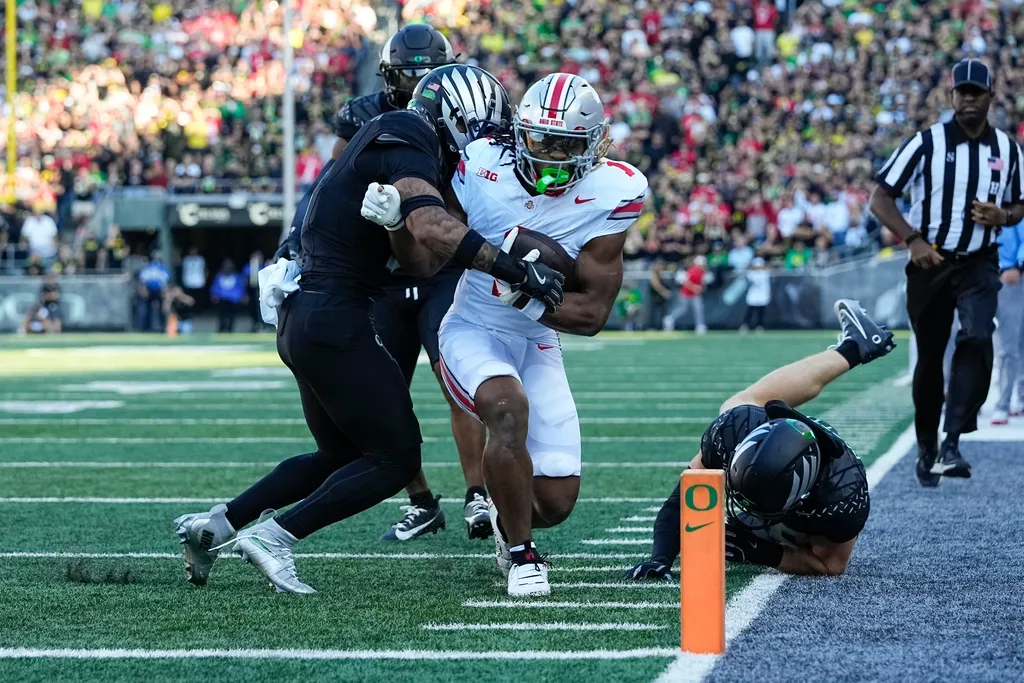 Ohio State Buckeyes running back Quinshon Judkins (1) is forced out of bounds by Oregon Ducks defensive back Tysheem Johnson (0) during the first half of the NCAA football game at Autzen Stadium