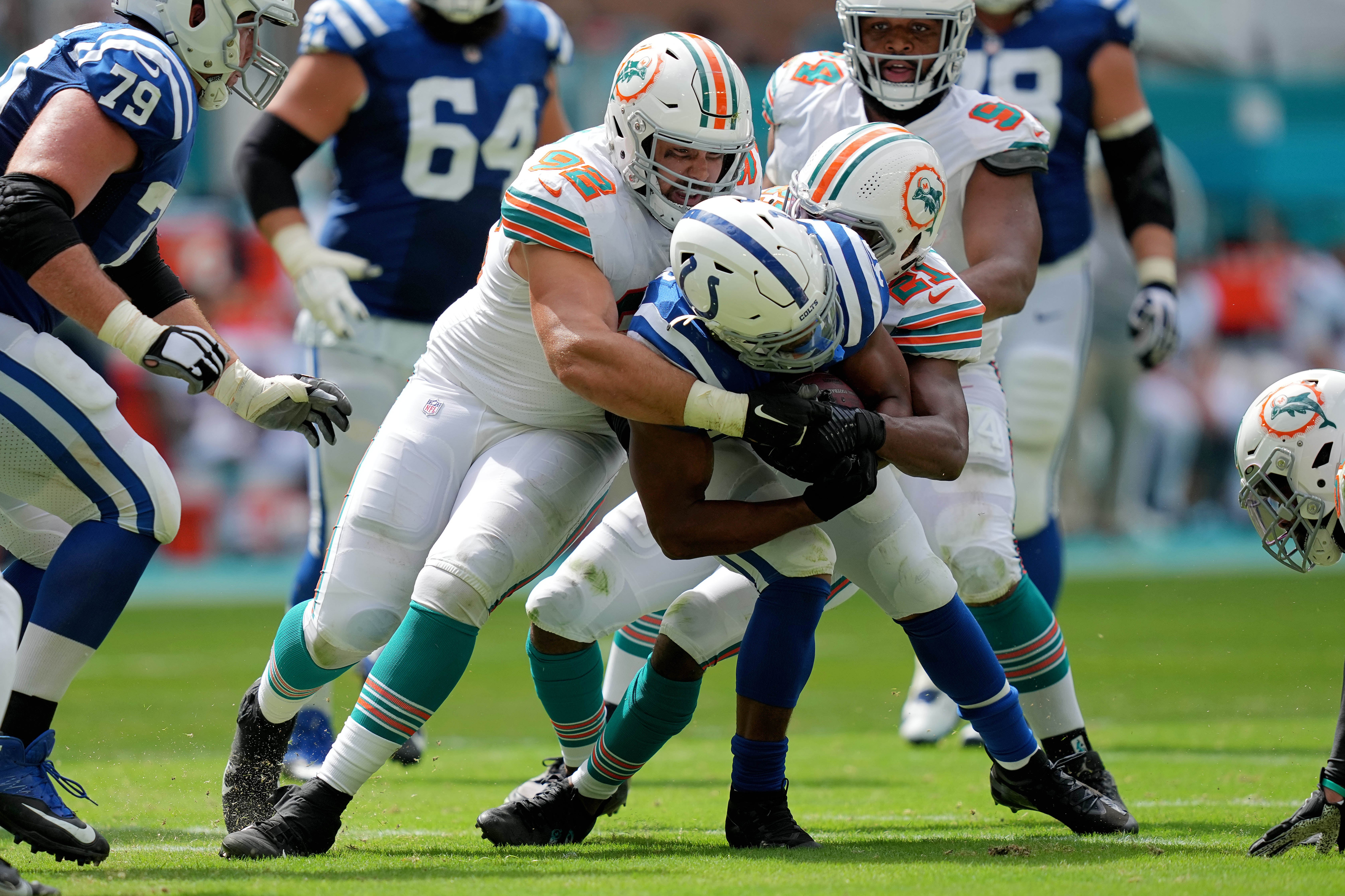 Oct 3, 2021; Miami Gardens, Florida, USA; Miami Dolphins defensive end Zach Sieler (92) and free safety Eric Rowe (21) tackle Indianapolis Colts running back Jonathan Taylor (28) during the second half at Hard Rock Stadium.