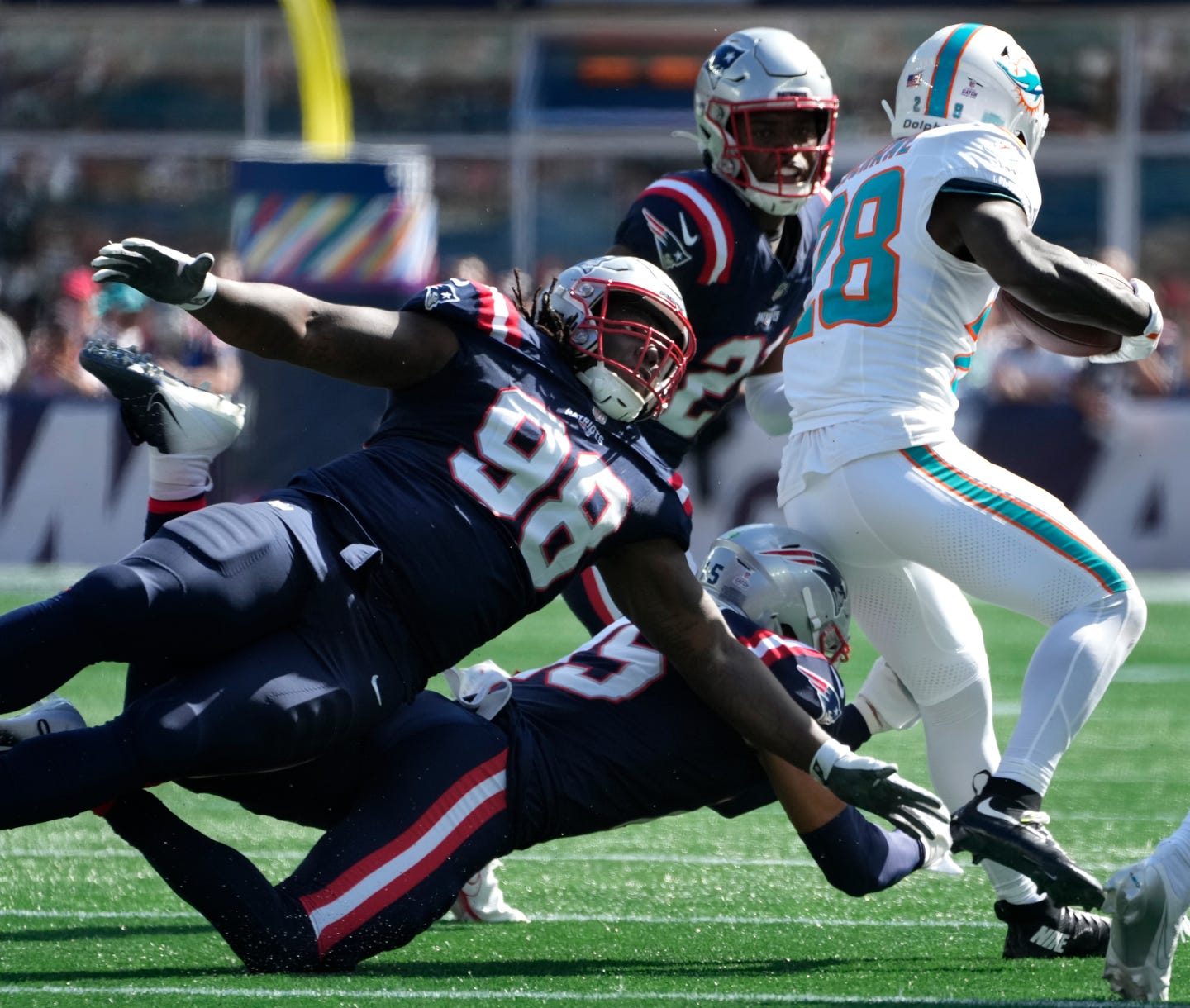 Jeremiah Pharms Jr., Marte Mapu and Jaylinn Hawkins pursue and bring down Miami running back De'Von Achane in the first half.