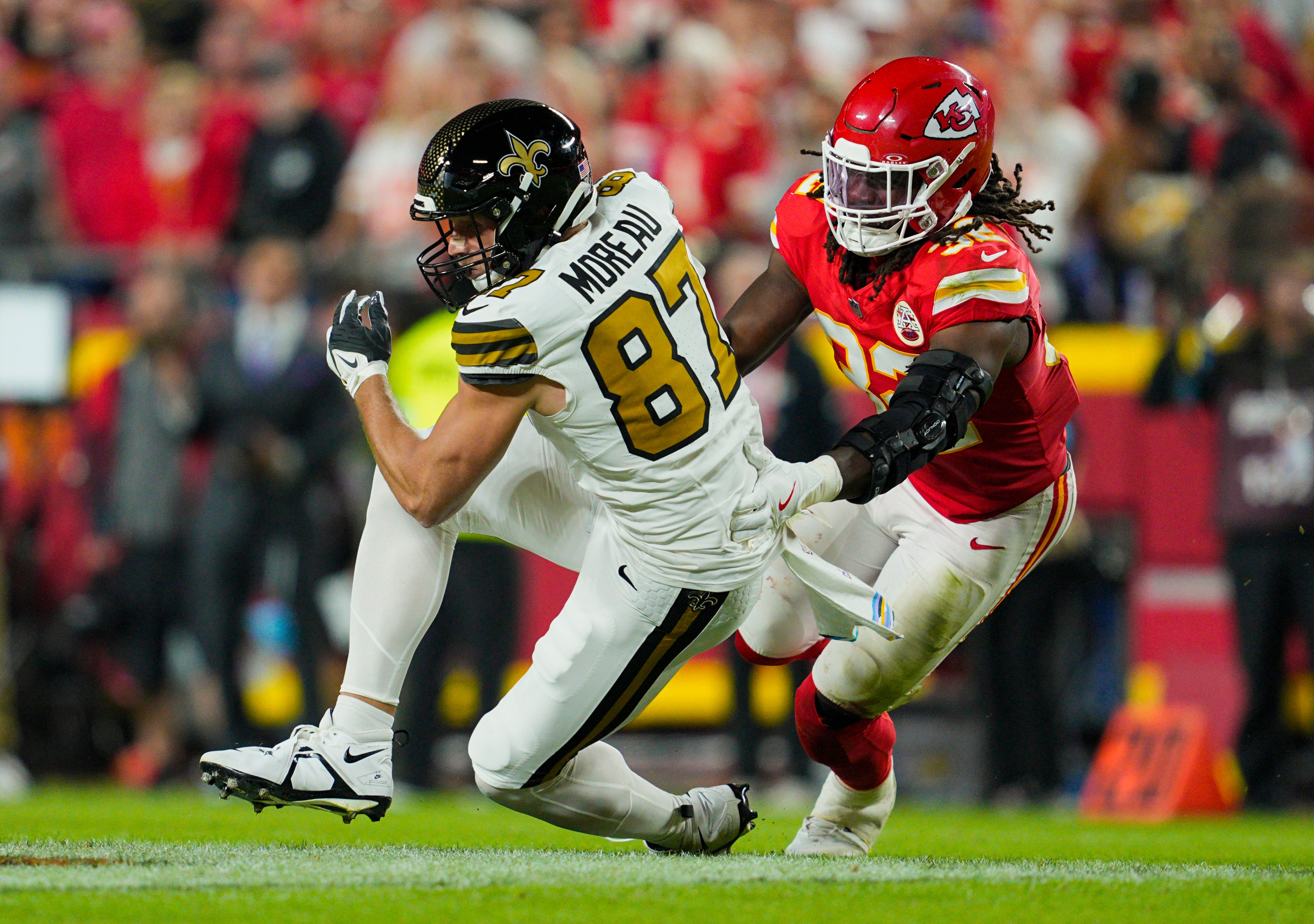 Saints tight end Foster Moreau catches a pass against Chiefs linebacker Nick Bolton.