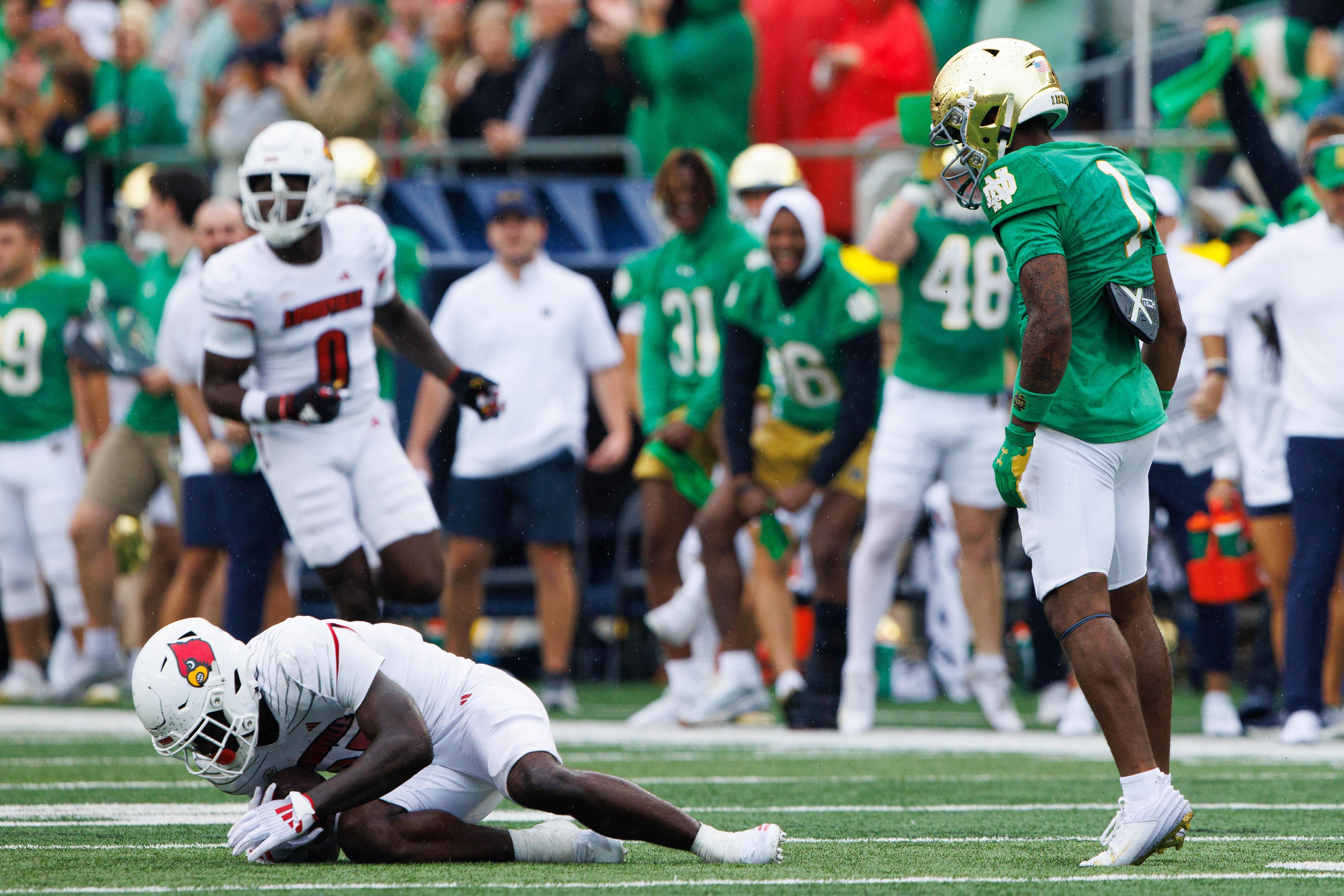 Notre Dame safety Jordan Clark, right, stares down Louisville running back Isaac Brown (25) after tackling him during a NCAA college football game between Notre Dame and Louisville at Notre Dame Stadium on Saturday, Sept. 28, 2024, in South Bend.
