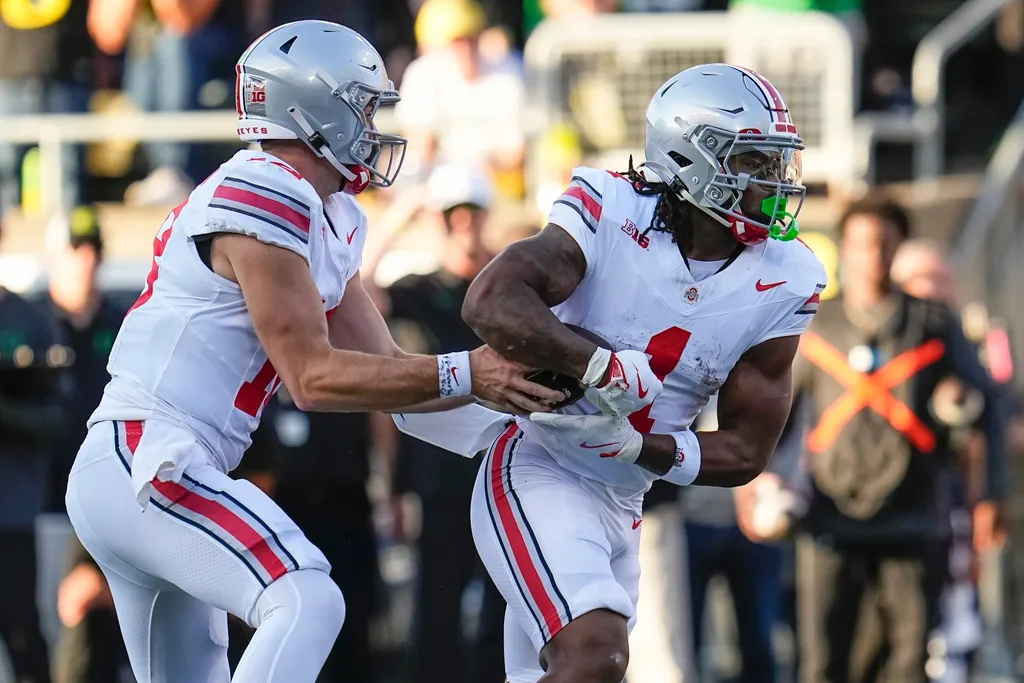 Ohio State Buckeyes quarterback Will Howard (18) hands off to running back Quinshon Judkins (1) during the first half of the NCAA football game against the Oregon Ducks at Autzen Stadium