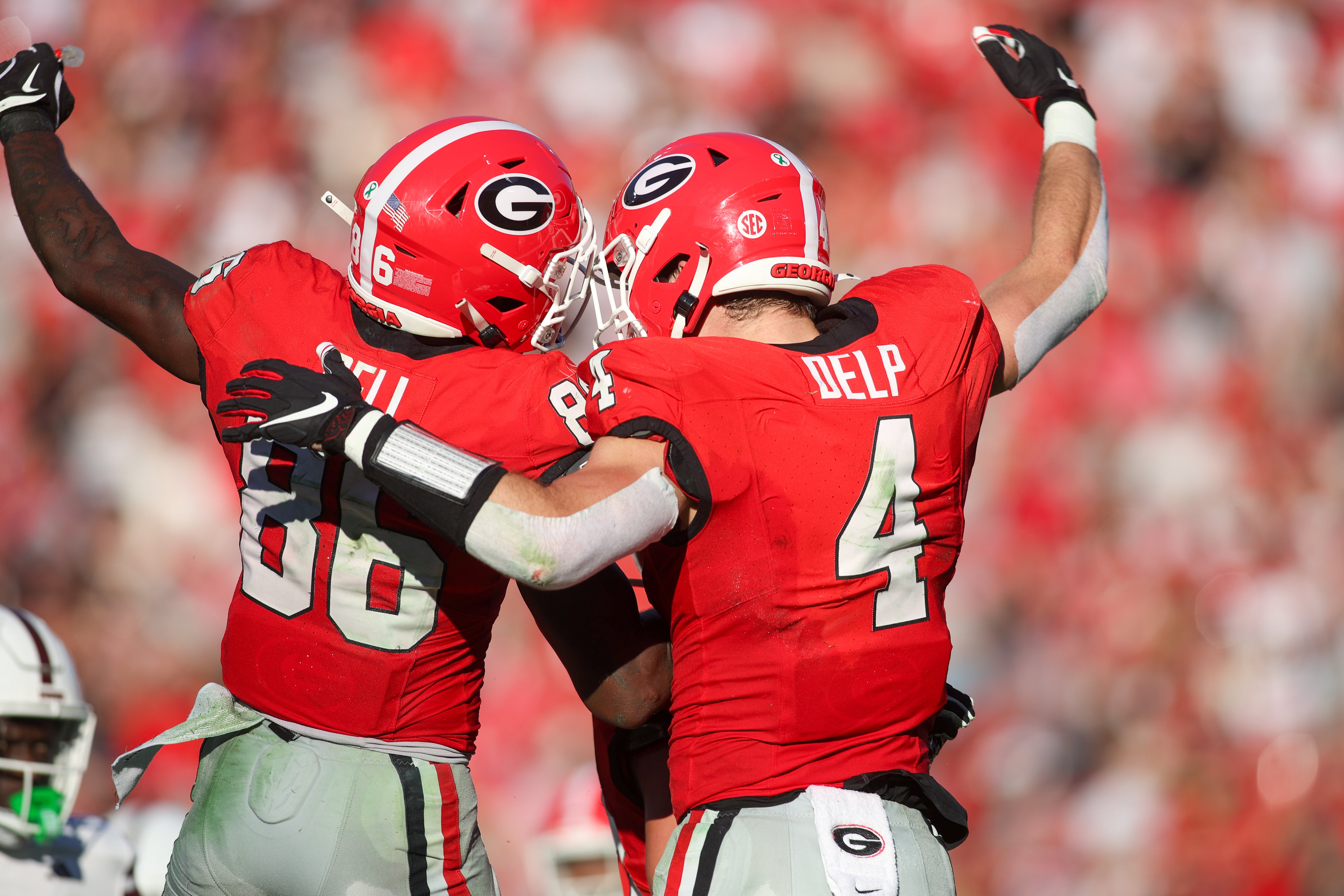 Georgia Bulldogs wide receiver Dillon Bell (86) celebrates with tight end Oscar Delp (4) after a touchdown catch against the Mississippi State Bulldogs in the second quarter at Sanford Stadium.