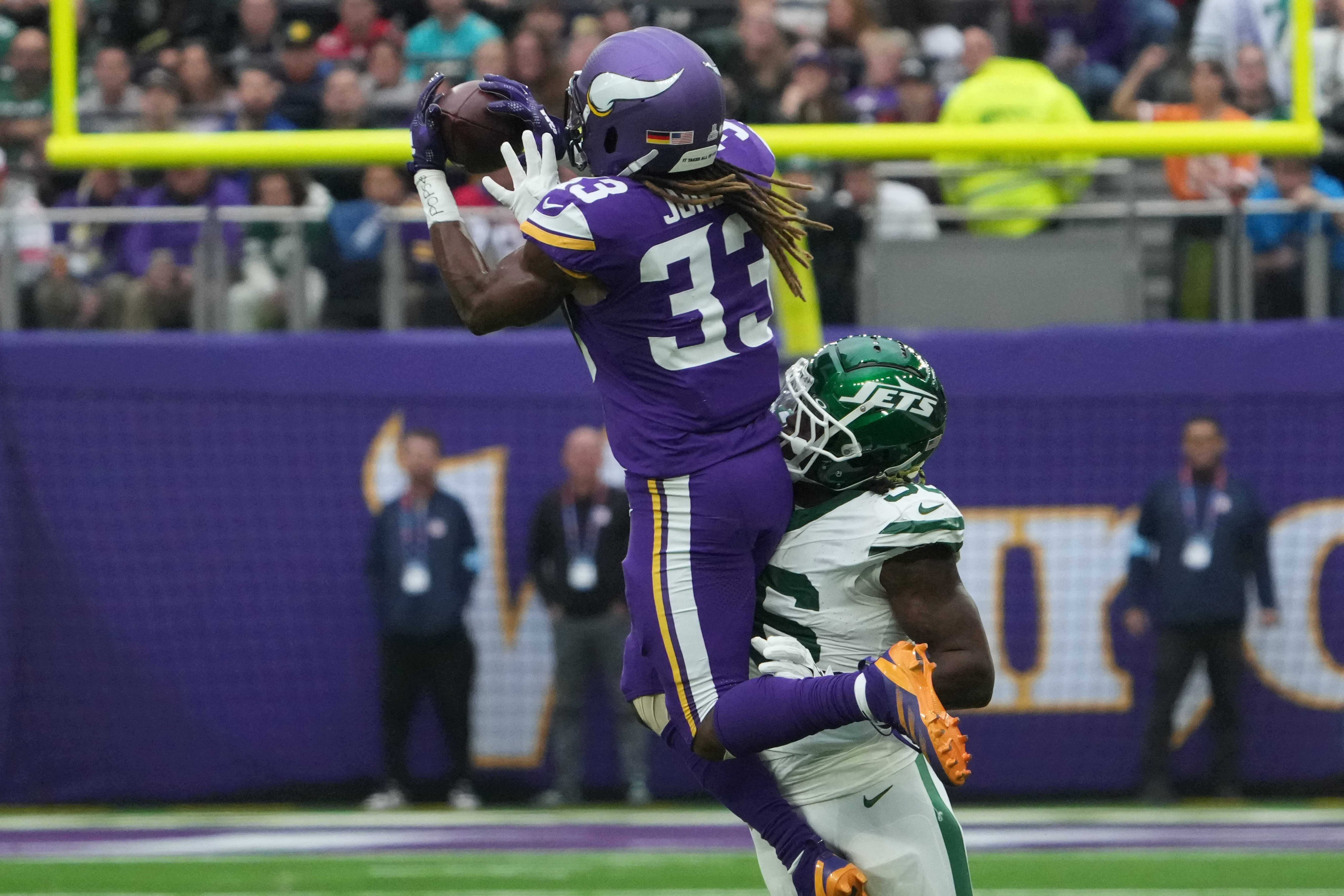 Oct 6, 2024; London, United Kingdom; Minnesota Vikings running back Aaron Jones (33) catches the ball against New York Jets linebacker Quincy Williams (56) in the first half at Tottenham Hotspur Stadium.