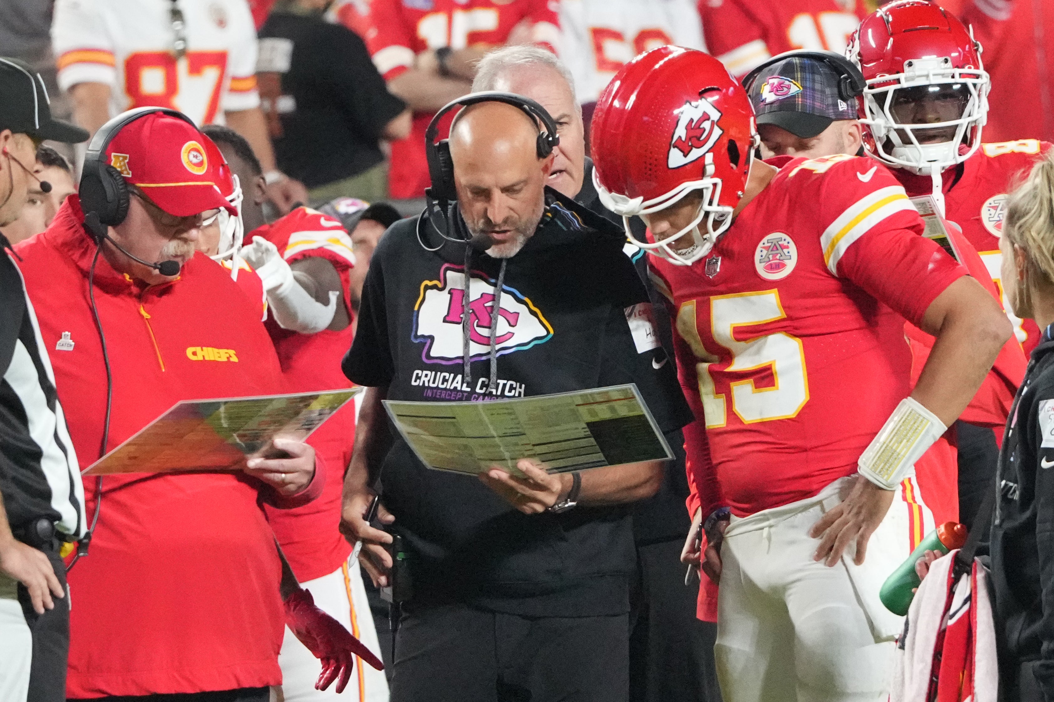 Oct 7, 2024; Kansas City, Missouri, USA; Kansas City Chiefs quarterback Patrick Mahomes (15) looks at plays with offensive coordinator Matt Nagy, center, and head coach Andy Reid against the New Orleans Saints during the first half at GEHA Field at Arrowhead Stadium.