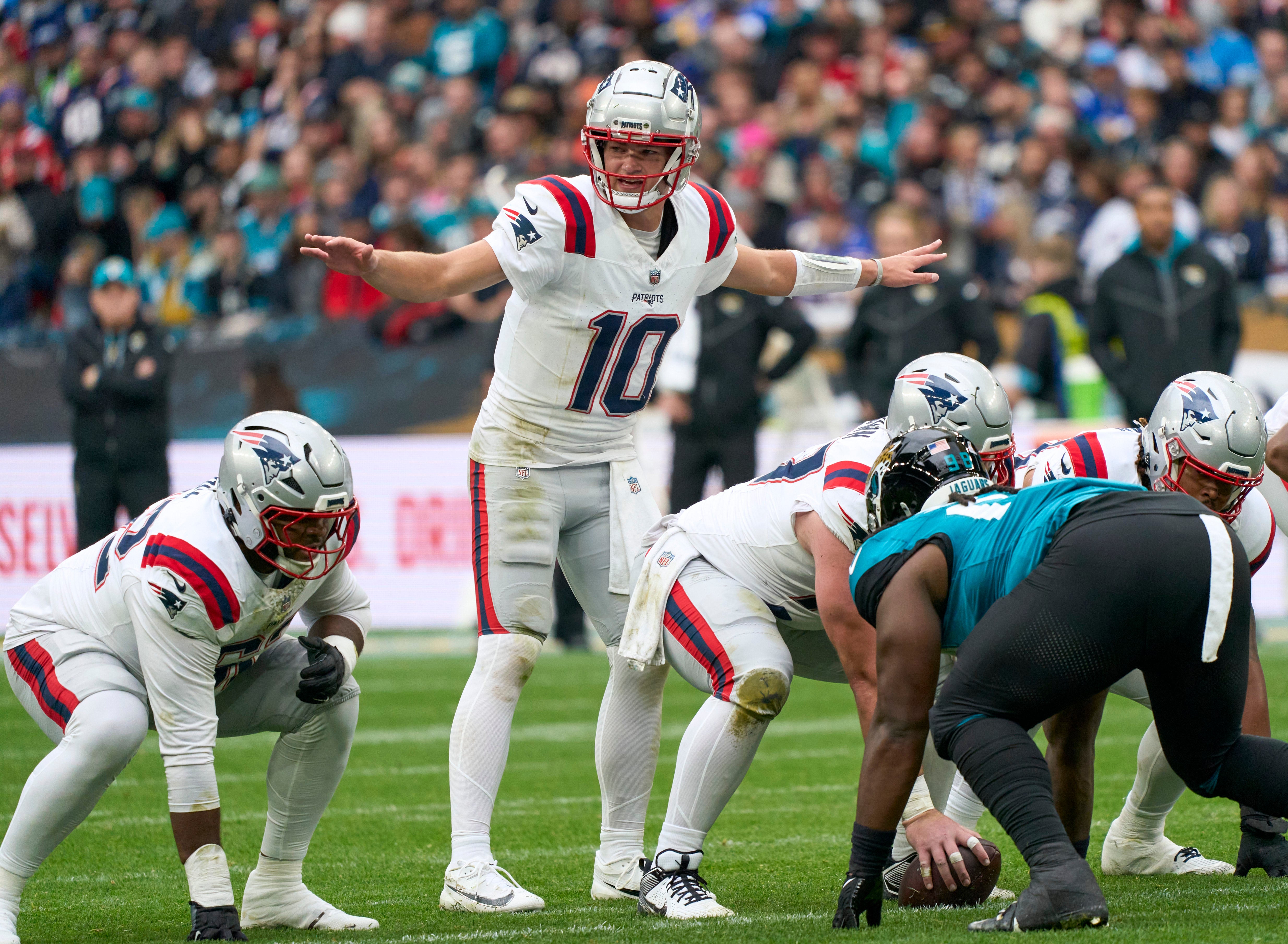 Oct 20, 2024; London, United Kingdom; New England Patriots quarterback Drake Maye (10) signs to players in the first half during an NFL International Series game at Wembley Stadium.