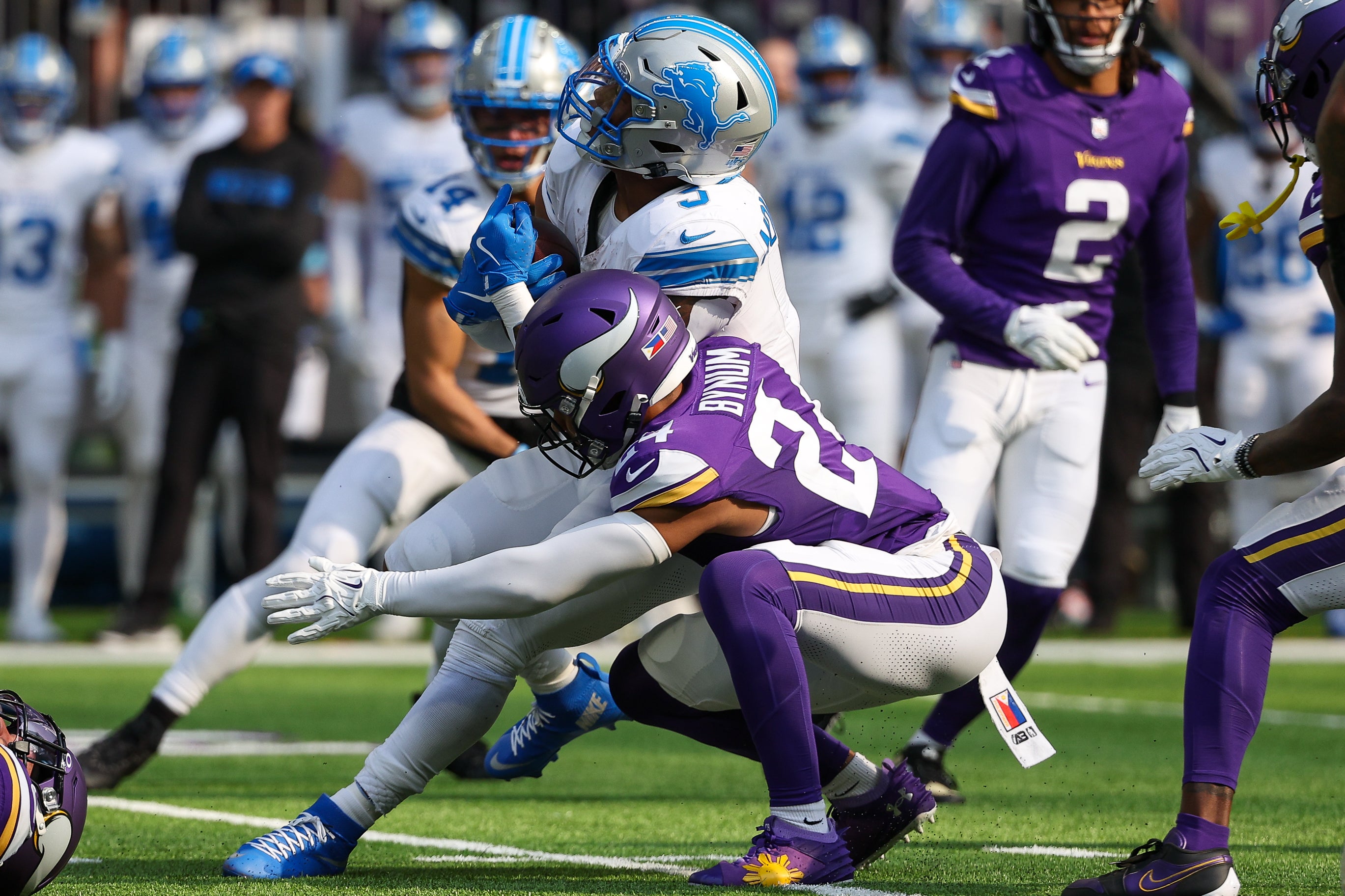 Oct 20, 2024; Minneapolis, Minnesota, USA; Minnesota Vikings running back Cam Akers (27) tackles Detroit Lions running back David Montgomery (5) during the first quarter at U.S. Bank Stadium.