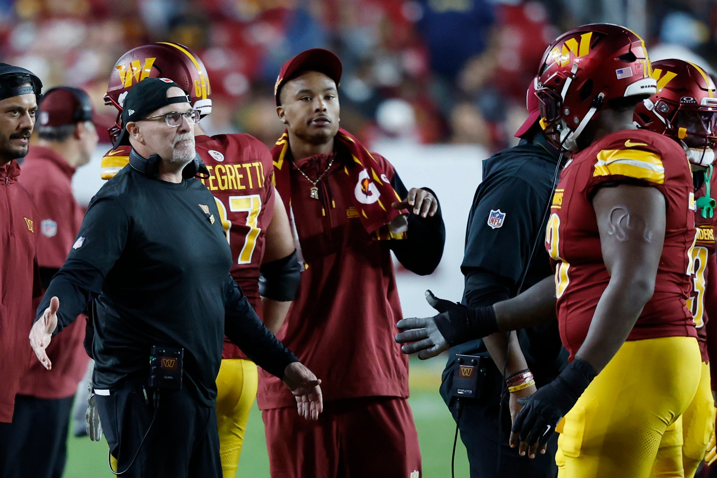 Oct 20, 2024; Landover, Maryland, USA; Washington Commanders head coach Dan Quinn (L) congratulates members of the offense after a touchdown drive against the Carolina Panthers during the fourth quarter at Northwest Stadium.