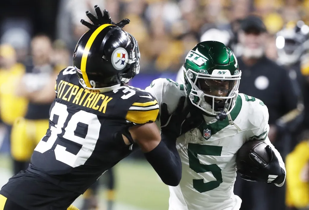 New York Jets wide receiver Garrett Wilson (5) runs after a catch as Pittsburgh Steelers safety Minkah Fitzpatrick (39) defends during the first quarter at Acrisure Stadium.
