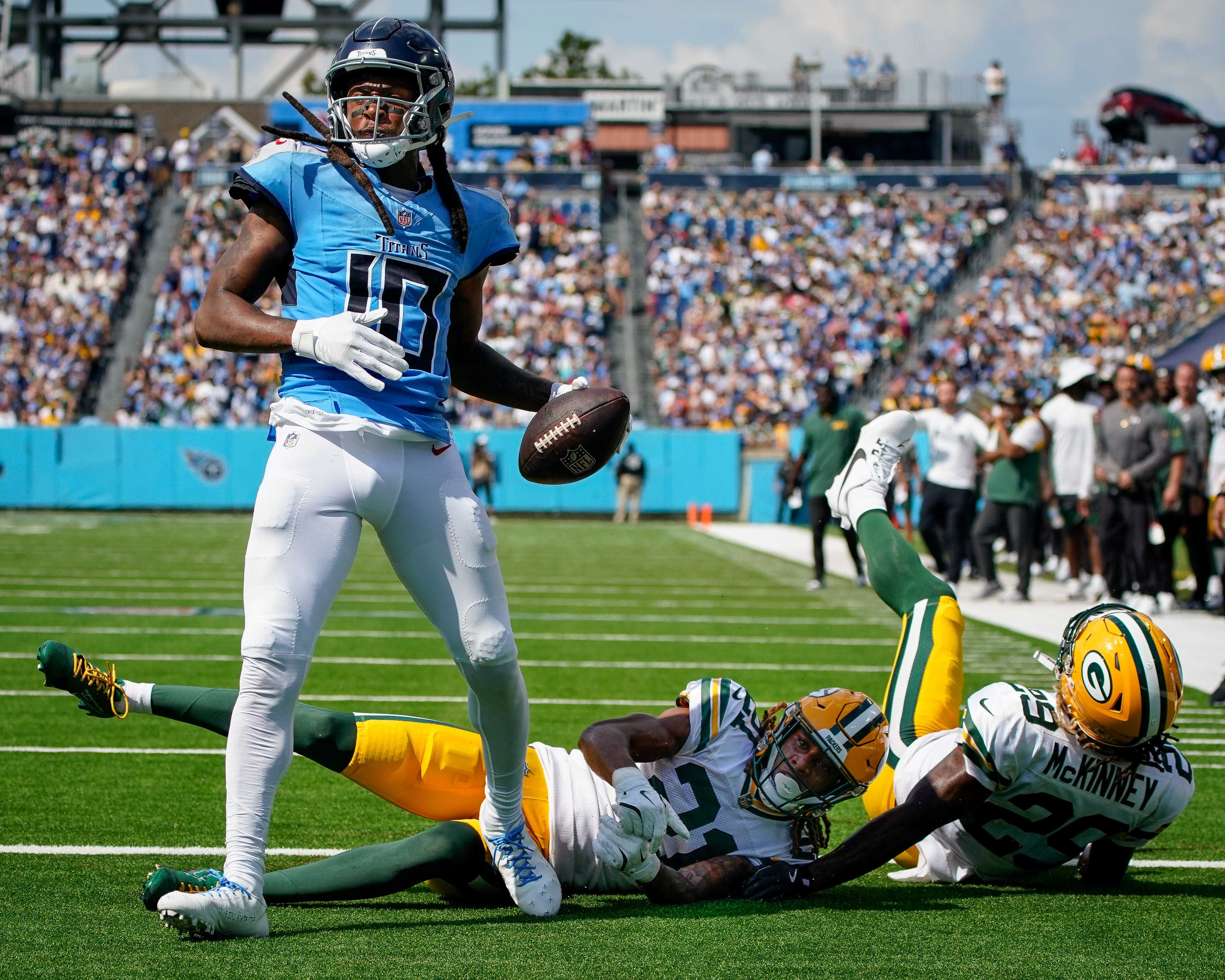 Tennessee Titans wide receiver DeAndre Hopkins (10) scores a touchdown past Green Bay Packers cornerback Eric Stokes (21) and safety Xavier McKinney (29) during the third quarter at Nissan Stadium in Nashville, Tenn., Sunday, Sept. 22, 2024.