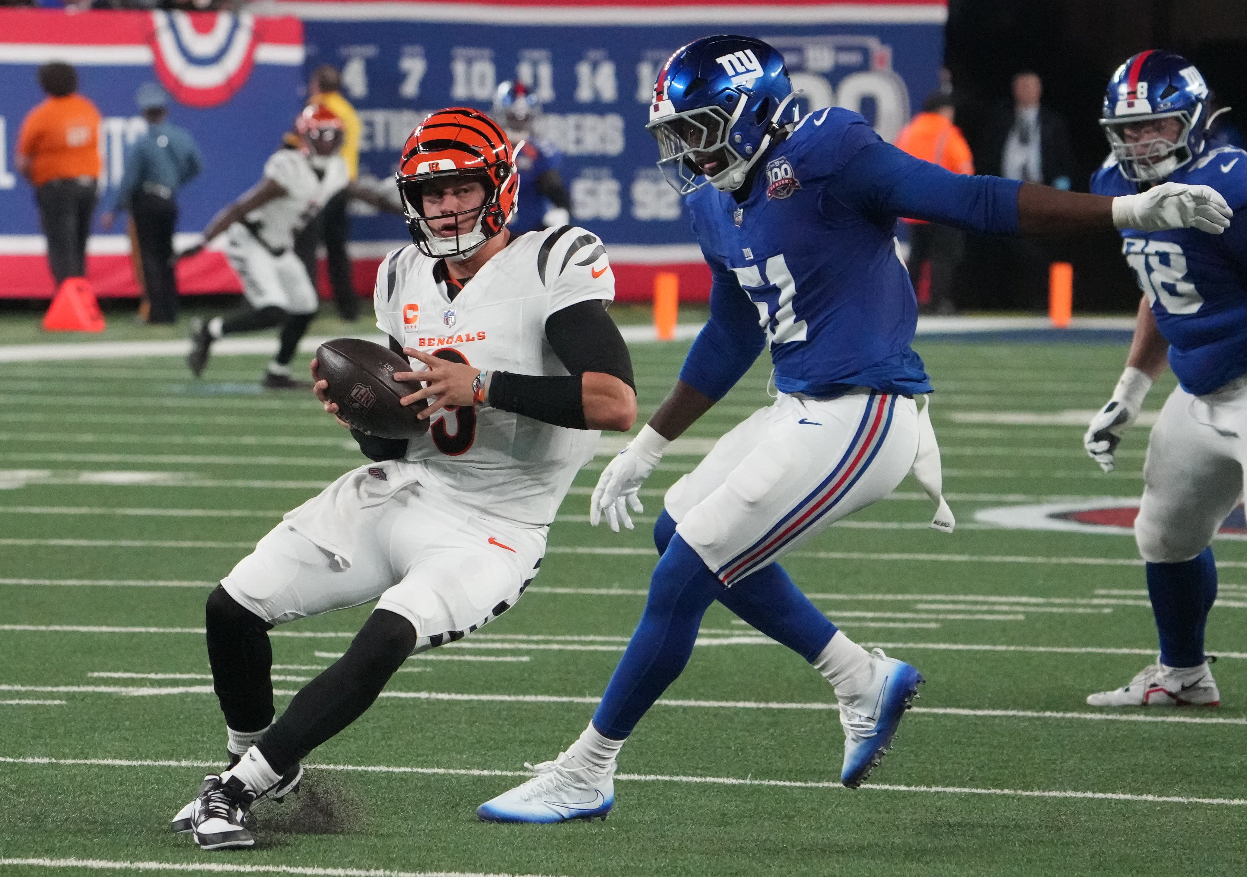 Oct 13, 2024; East Rutherford, New Jersey, USA; Cincinnati Bengals quarterback Joe Burrow (9) is chased by New York Giants linebacker Azeez Ojulari (51) during the first half at MetLife Stadium.