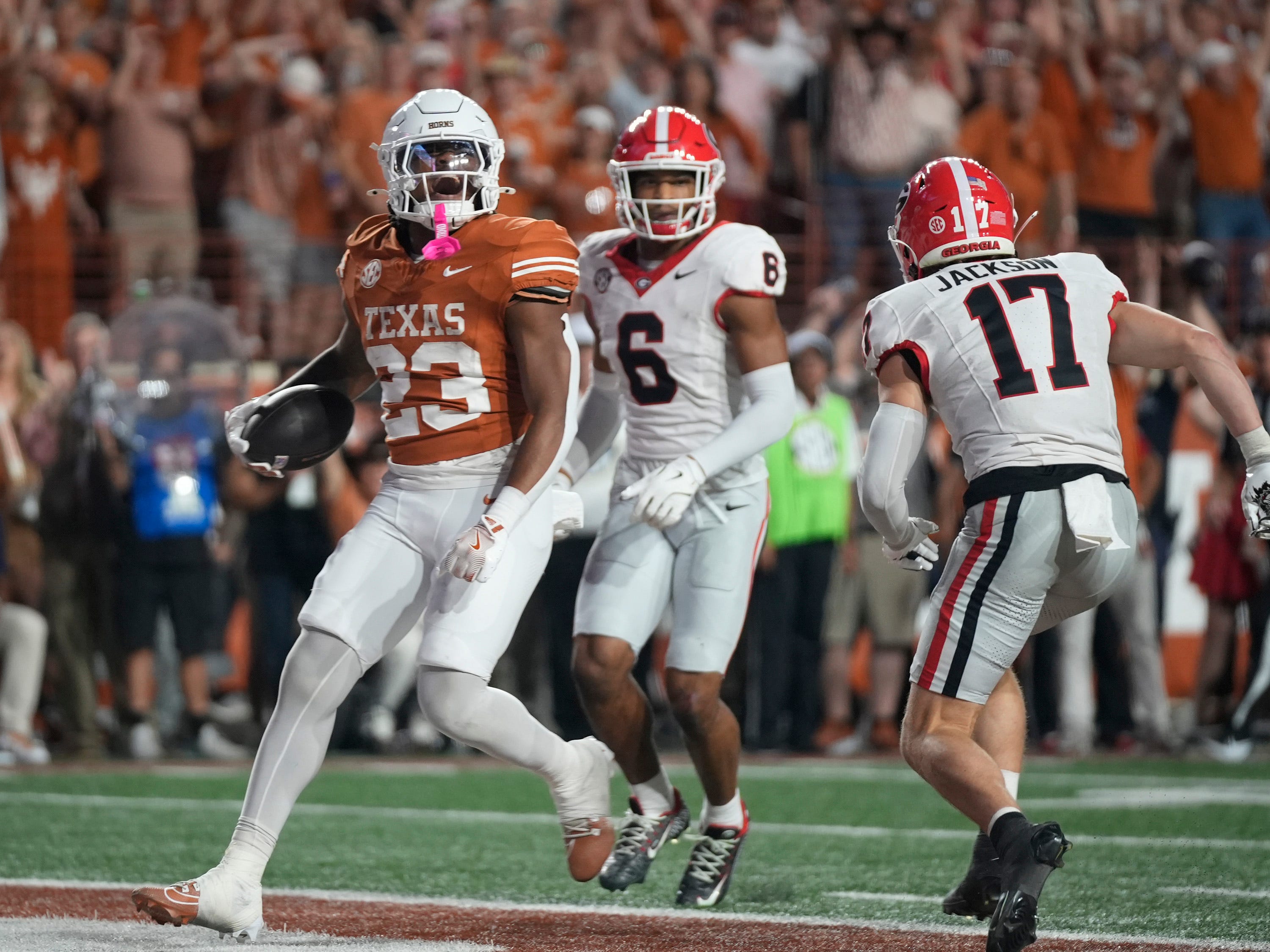 Texas Longhorns running back Jaydon Blue scores a touchdown against Georgia Bulldogs defensive back Daylen Everette, left, and Georgia Bulldogs defensive back Dan Jackson in the third quarter