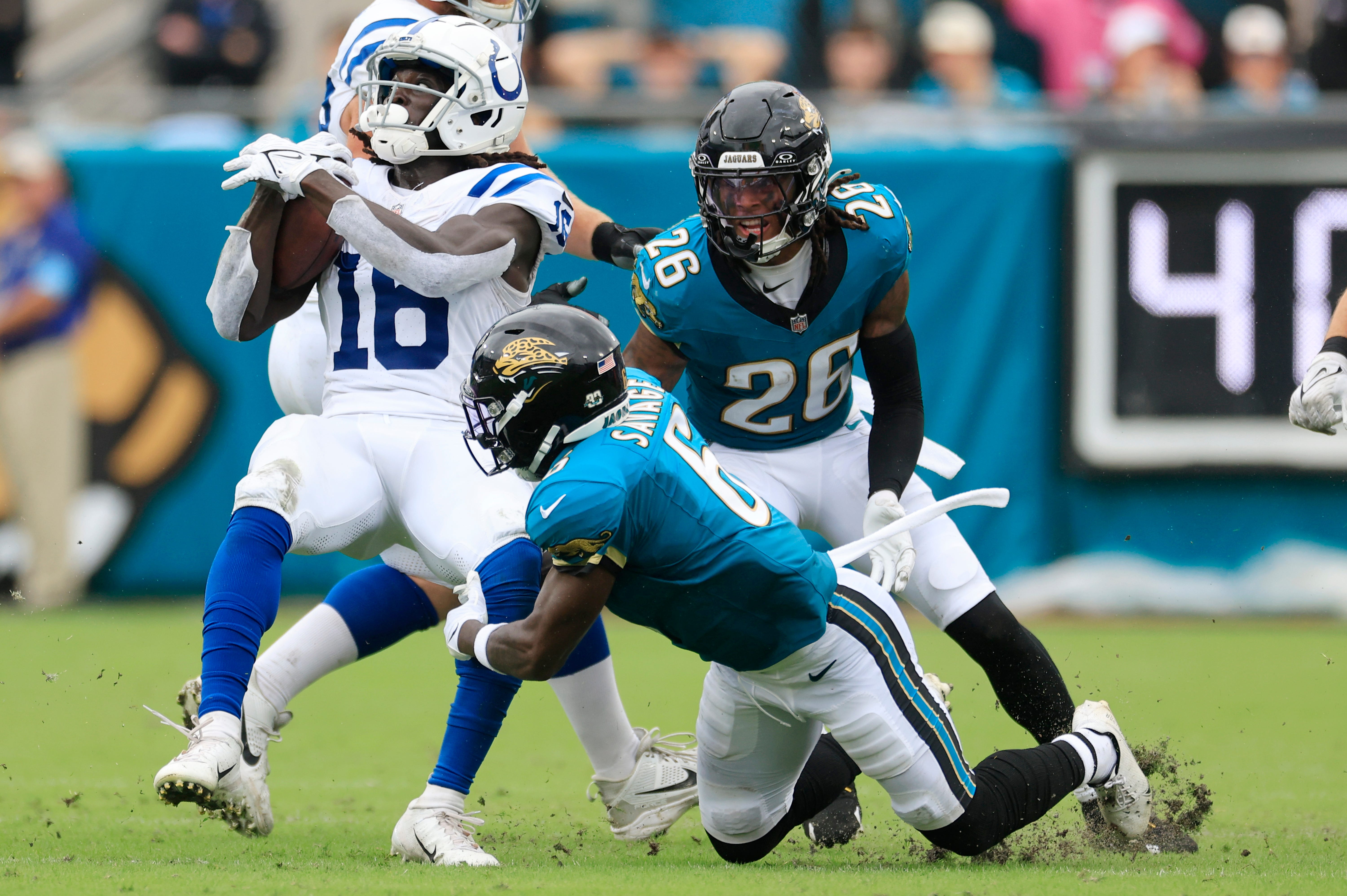 Indianapolis Colts wide receiver Ashton Dulin (16) is tackled by Jacksonville Jaguars safety Darnell Savage (6) as safety Antonio Johnson (26) looks on during the third quarter of an NFL football matchup Sunday, Oct. 6, 2024 at EverBank Stadium in Jacksonville, Fla.